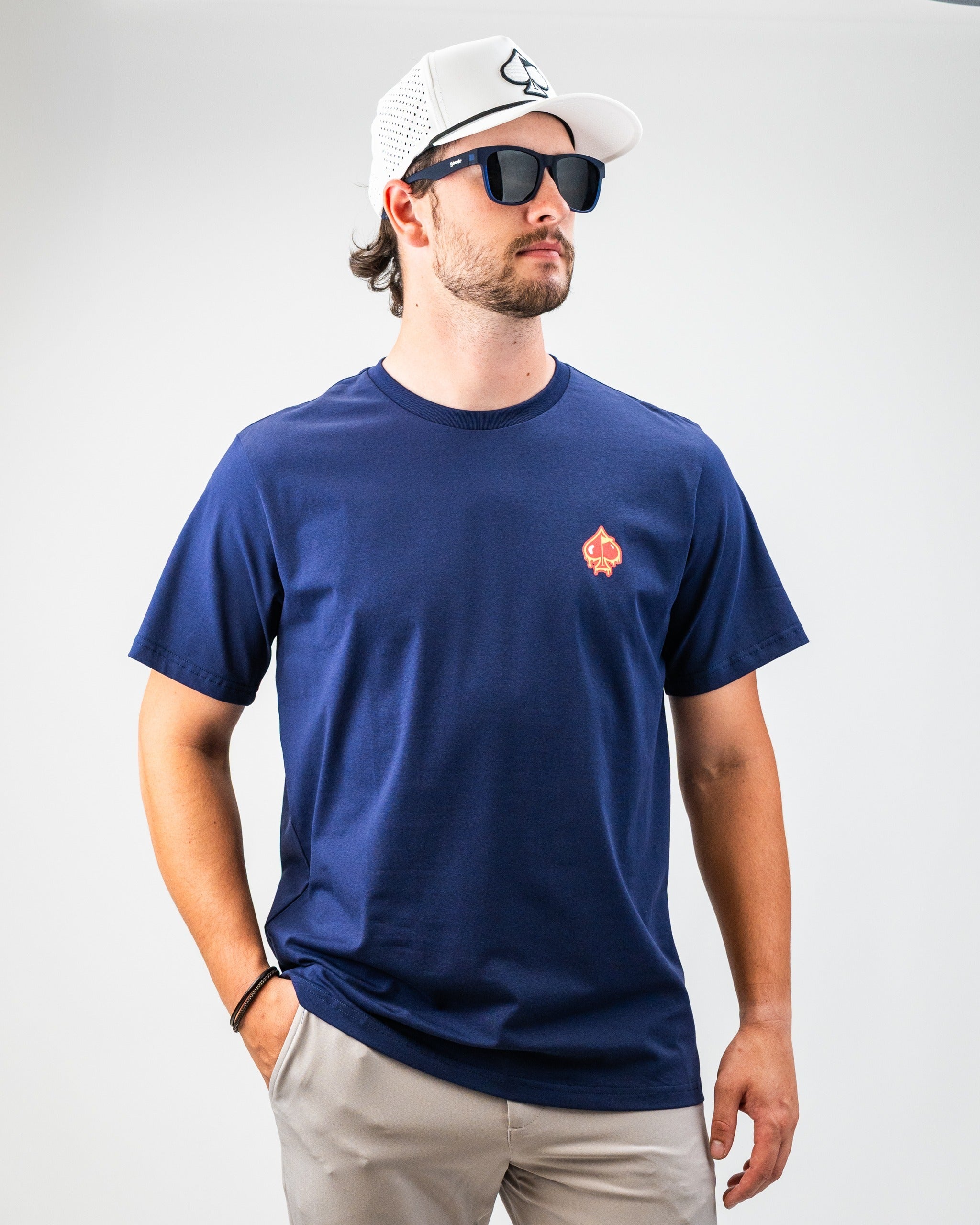 Navy blue tee featuring a small Louisiana Hot Sauce logo with dancing peppers, perfect for bold golf style on the course.