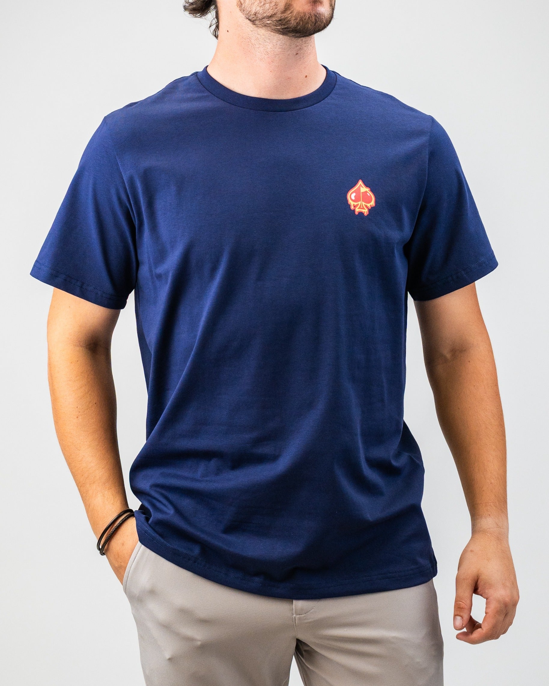 Men's navy blue golf t-shirt with a small red and yellow spade logo on the chest, perfect for bold golf style.