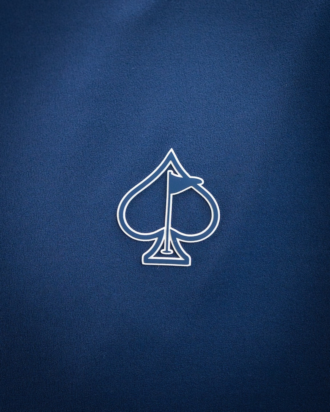 Close-up of a blue golf accessory with a white spade logo, perfect for bold, standout golf apparel and unique headcovers.
