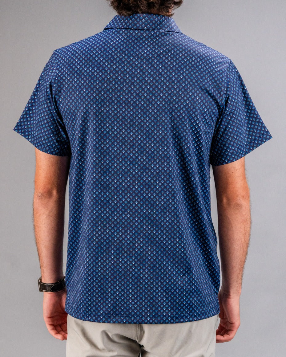 Blue golf shirt with a small diamond pattern, short sleeves, and a collared neckline, perfect for bold golf style.