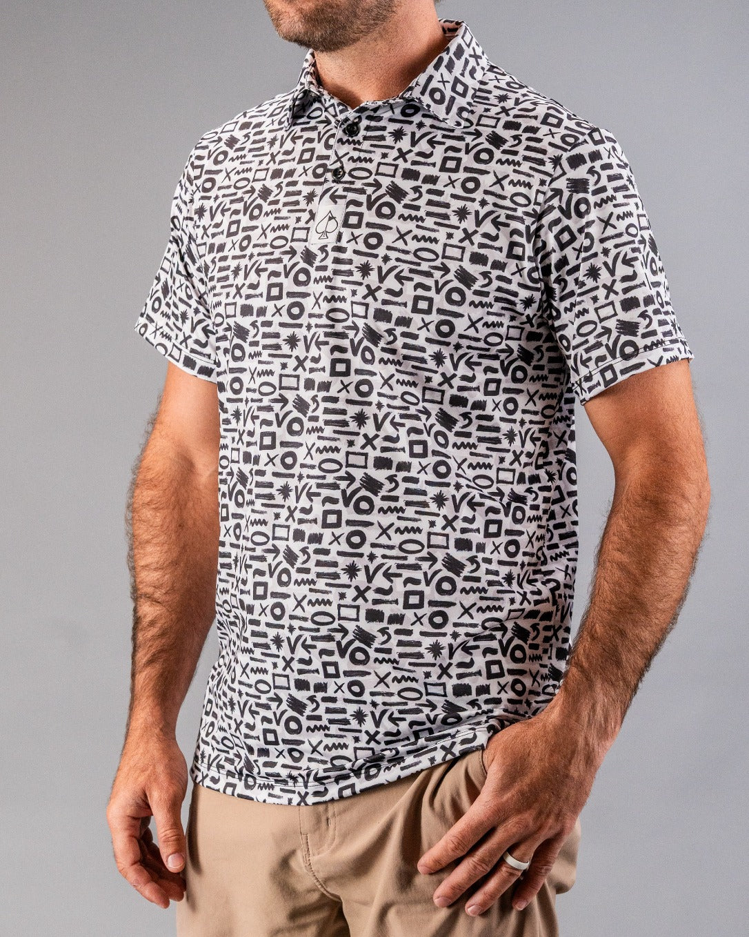 Men's short-sleeve golf shirt featuring a bold brushed symbols pattern in black and white, ideal for stylish golfers.
