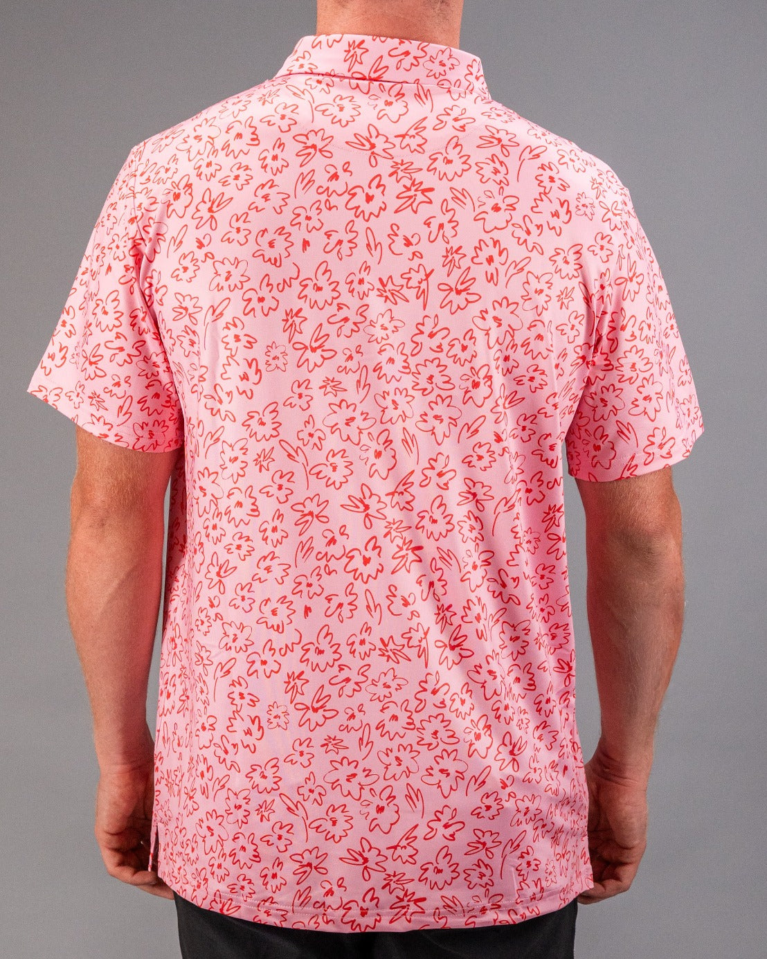 Men's short-sleeve golf shirt in pink with a playful flower doodle pattern, perfect for a stylish day on the course.