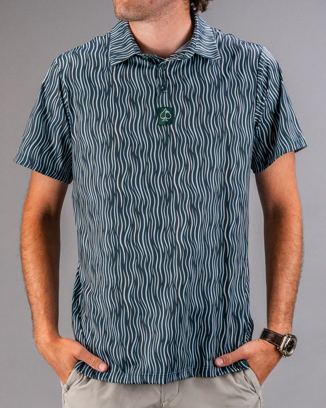 Men's short-sleeve golf shirt with a wavy blue pattern, featuring a green logo on the collar for a stylish look on the course.