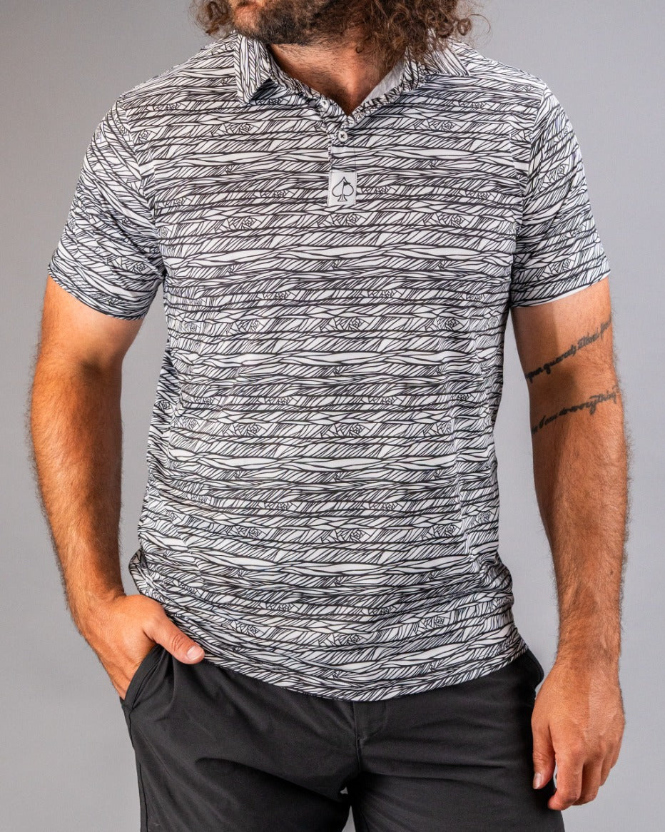 Men's Fragment Black golf polo featuring a bold black and white abstract pattern, perfect for stylish performance on the course.