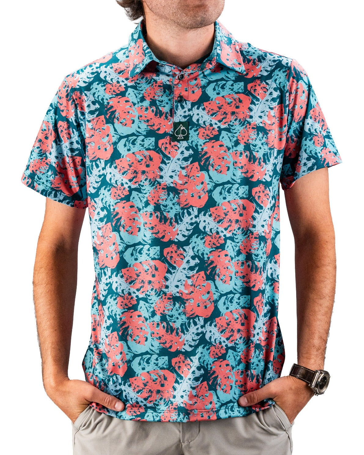 Bold golf polo featuring a vibrant painted monstera leaf pattern in teal and coral, perfect for stylish golfers.