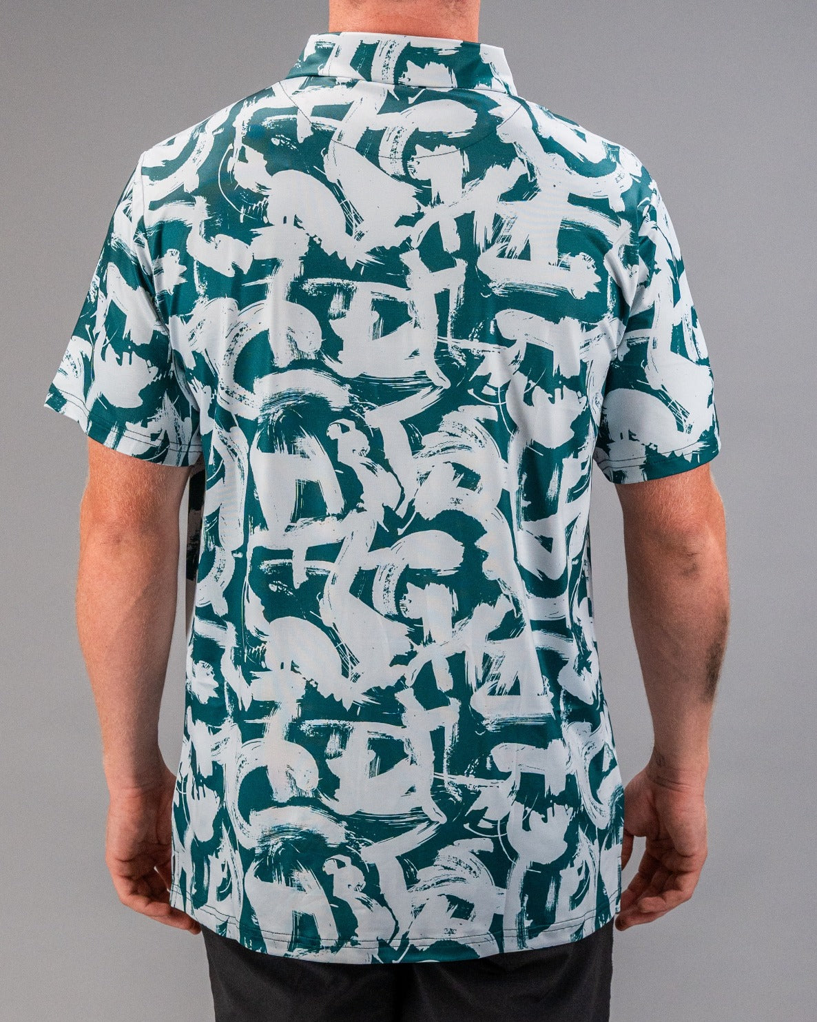 Men's short-sleeve golf shirt featuring a bold green and white paint stroke pattern, designed for a stylish look on the course.