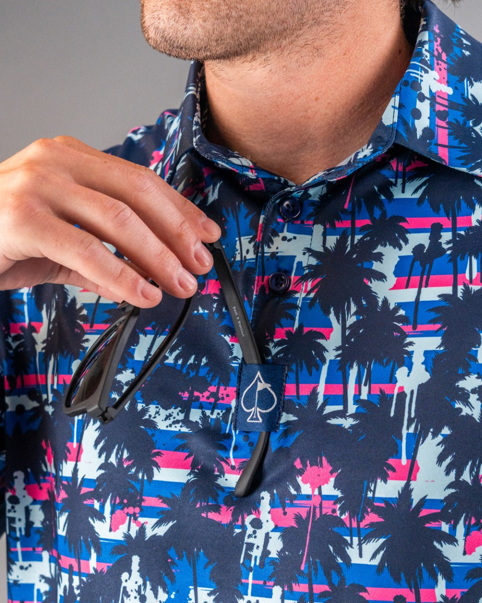 Bold golf polo featuring a vibrant palm tree design in blue and pink, perfect for stylish golfers on the course.