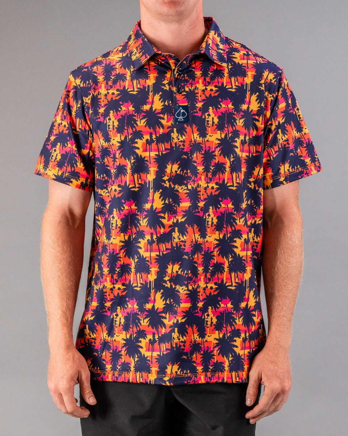 Bold short-sleeve golf shirt featuring a vibrant palm tree pattern in sunset colors, perfect for stylish golfers.