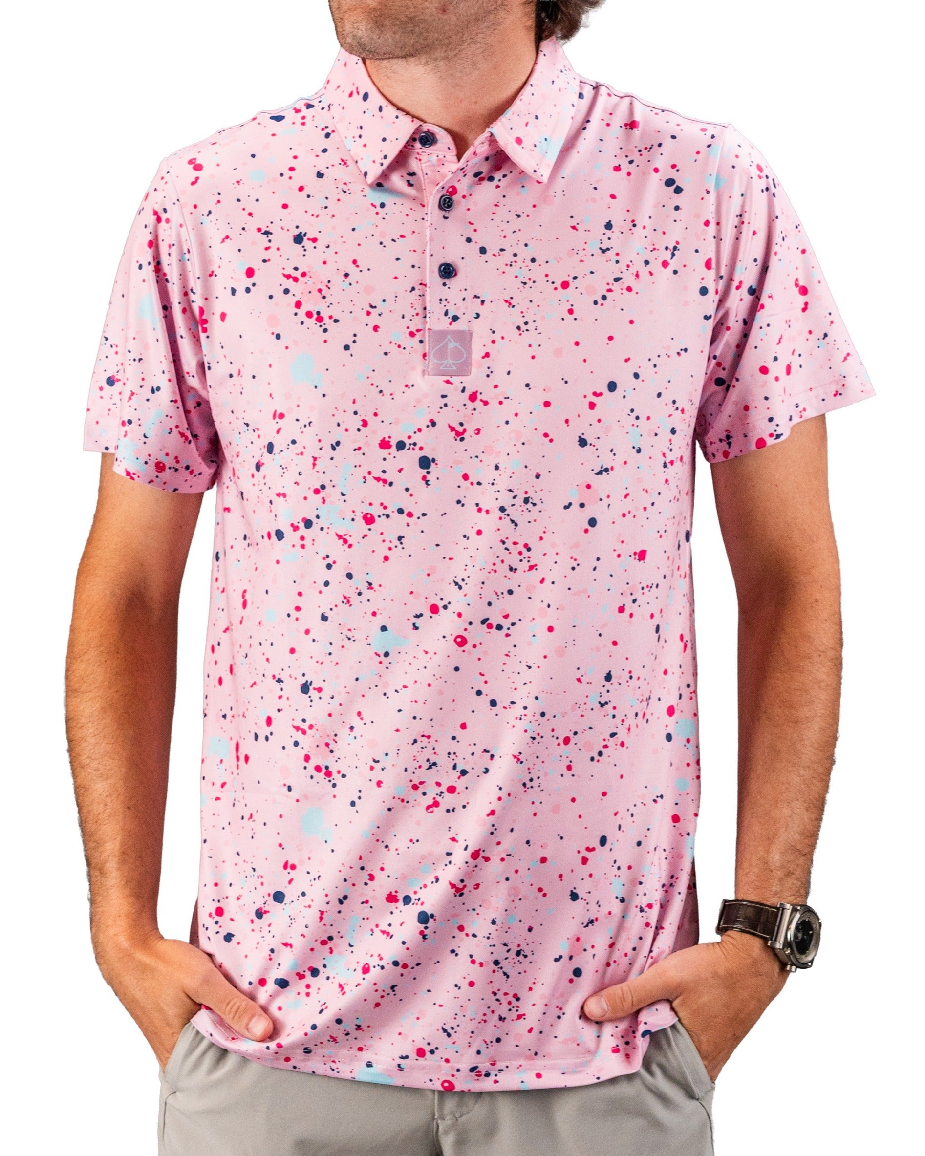 Men's pink golf polo shirt featuring a vibrant splatter design in shades of pink, blue, and purple for a bold look on the course.