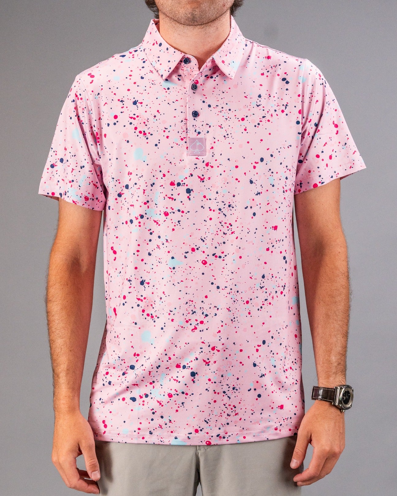 Men's golf polo shirt featuring a pink splatter design with vibrant colors, perfect for making a statement on the course.