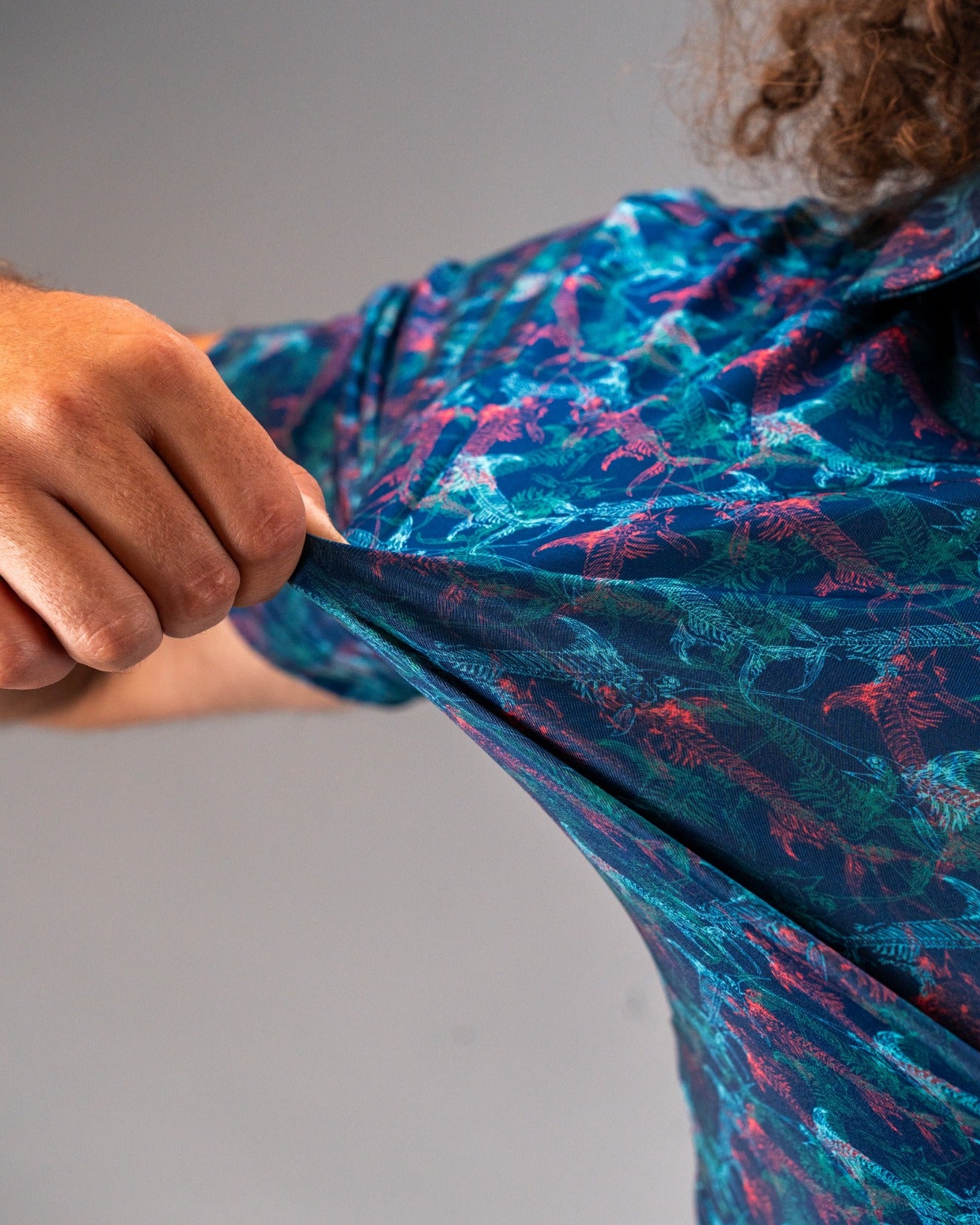 Bold Swordfish Skelly golf shirt featuring a vibrant tropical pattern, showcasing its flexible fabric and stylish design.