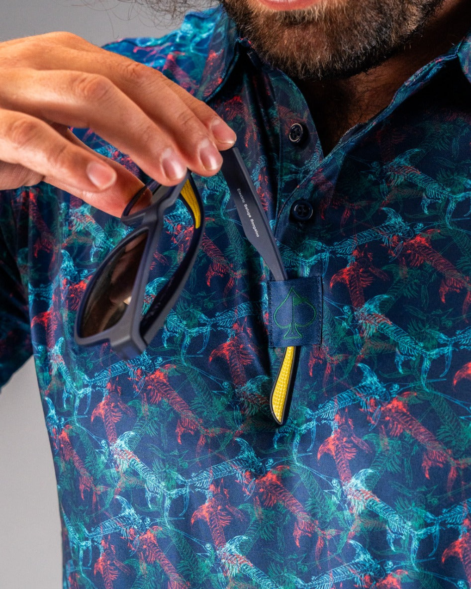Bold golf polo featuring a vibrant swordfish pattern, with a golfer holding sunglasses near the collar.