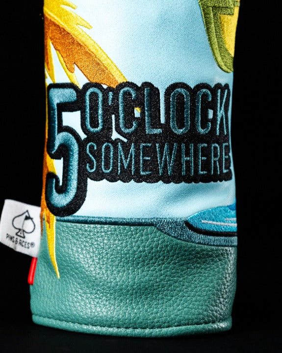 Colorful Margaritaville 5 O'Clock Somewhere fairway headcover featuring palm trees and vibrant lettering for stylish golf gear.