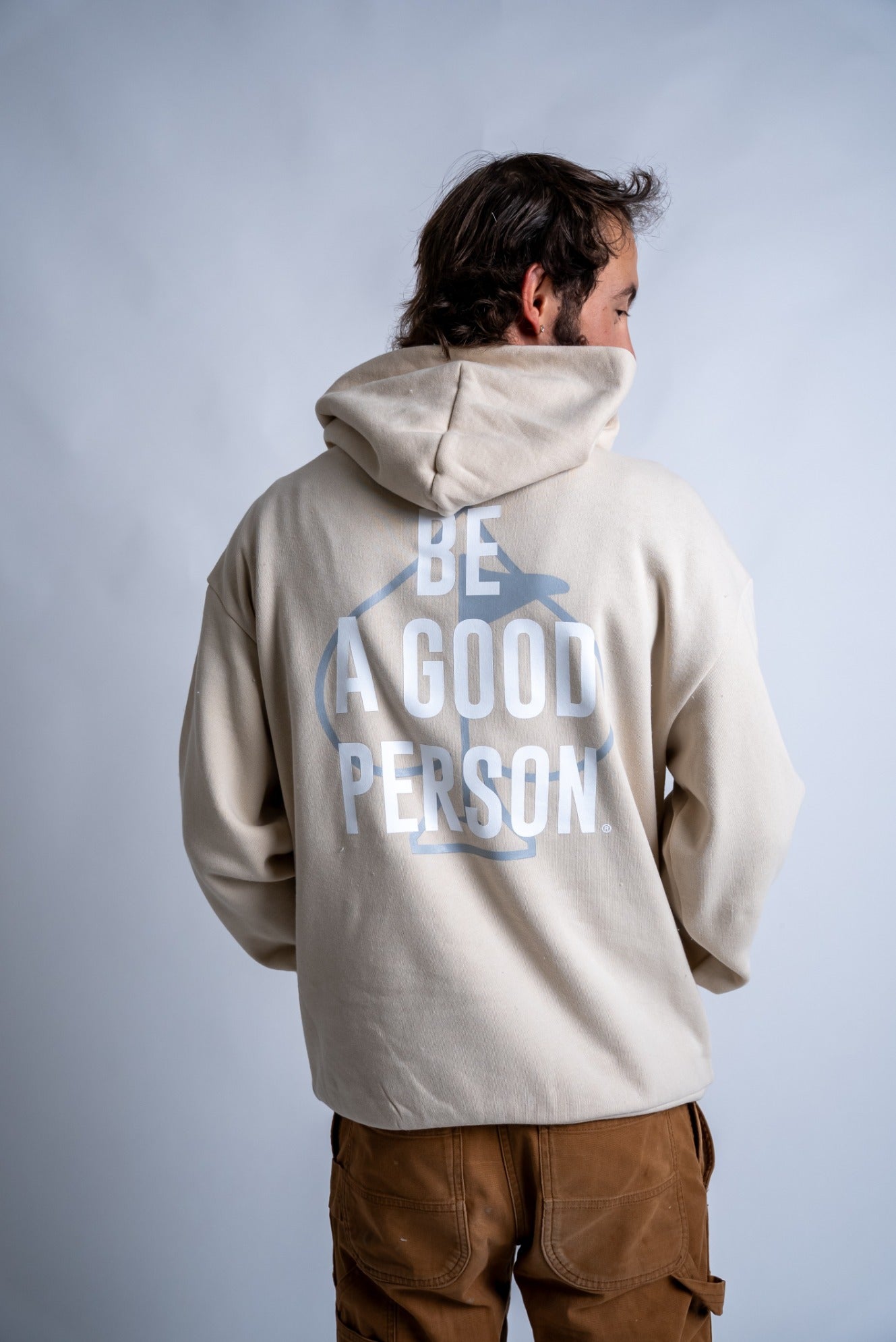 Cream hoodie featuring "Be A Good Person" graphic on the back, designed for stylish golfers who value positivity.