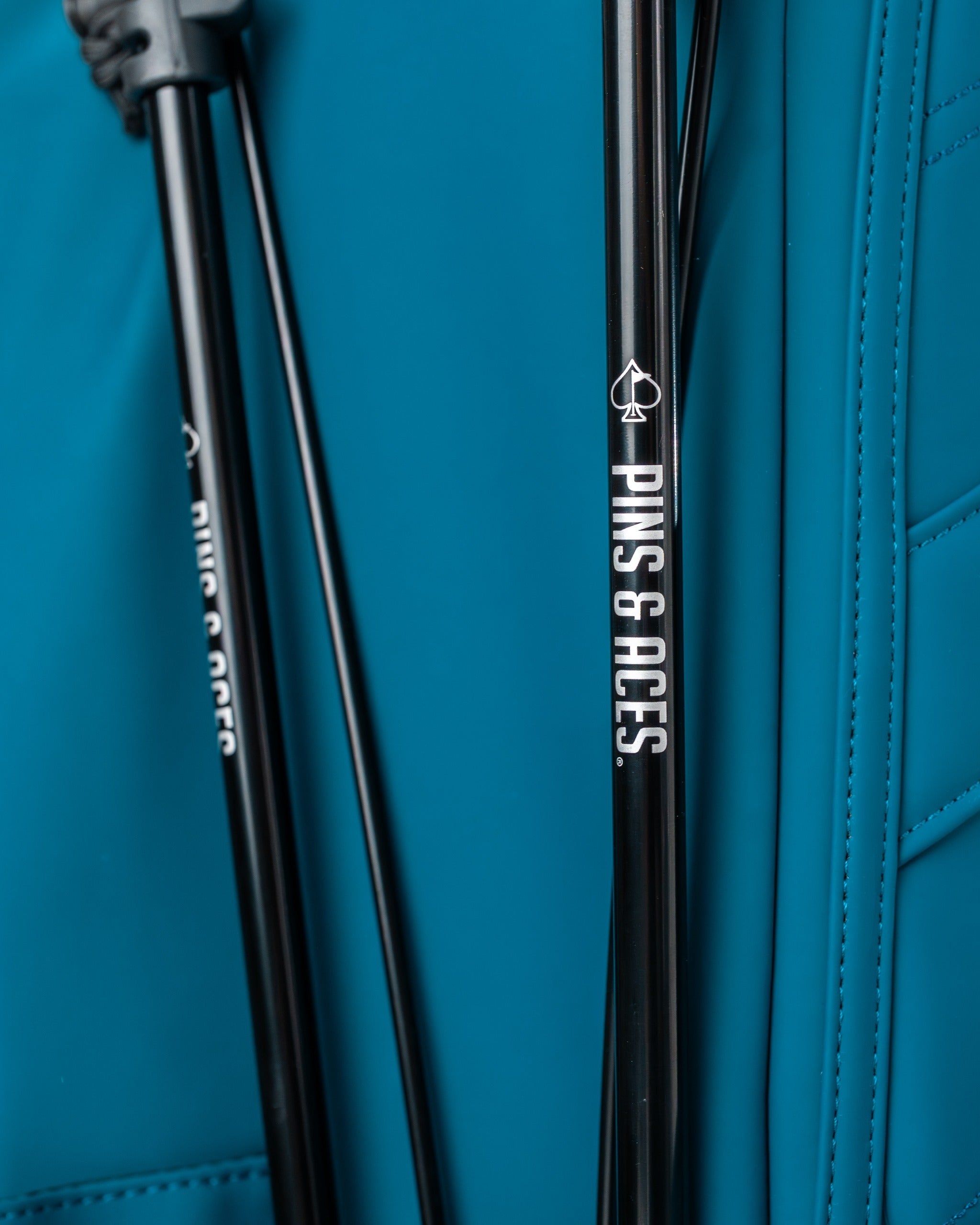 Close-up of the Player Preferred Golf Bag in Sea Strike, featuring sleek design and Pins & Aces branding on the legs.