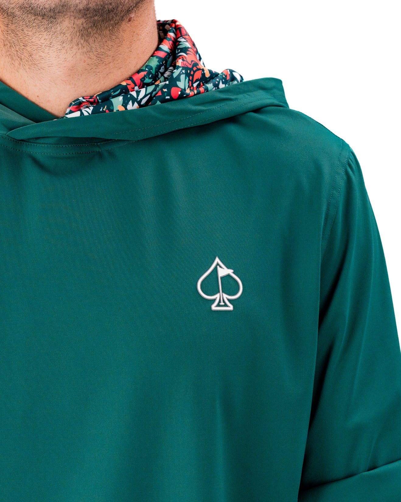 Teal performance golf hoodie featuring a floral-patterned hood and a logo on the chest, designed for stylish golfers.