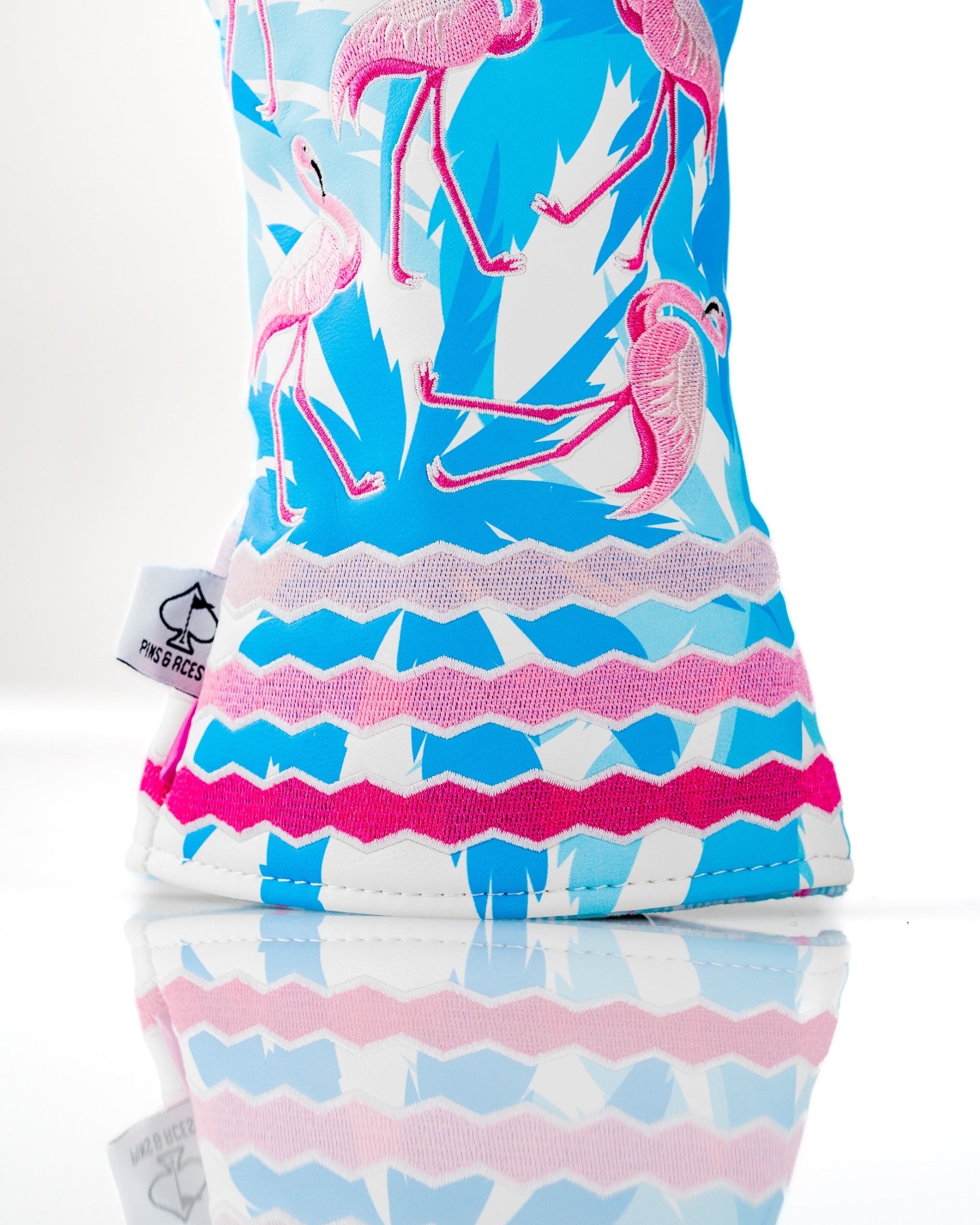 Bright blue driver cover featuring vibrant pink flamingos and a stylish zigzag pattern, perfect for bold golfers.