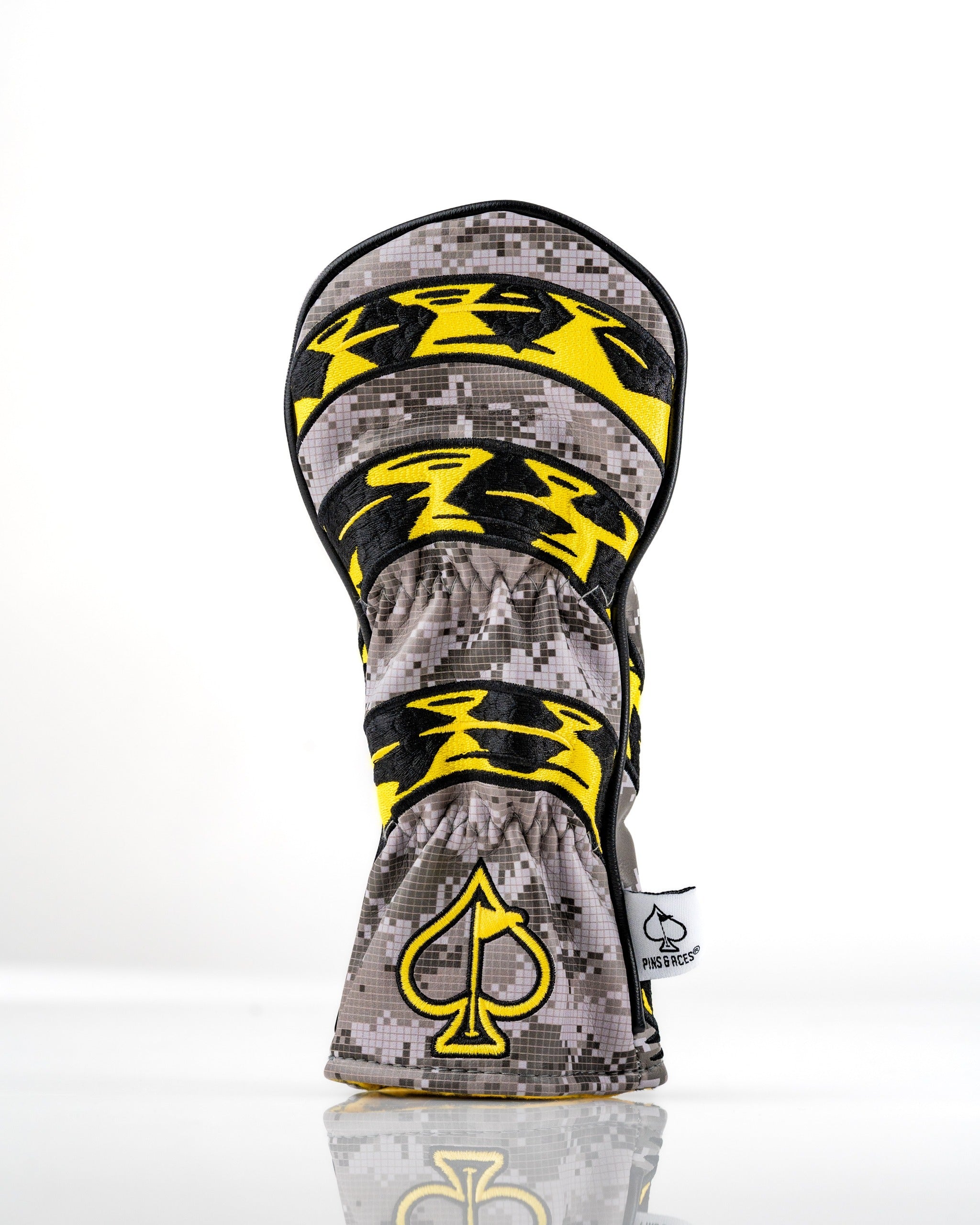 Bold hybrid golf headcover featuring a camouflage design with yellow accents and a distinctive logo, perfect for standout style on the course.