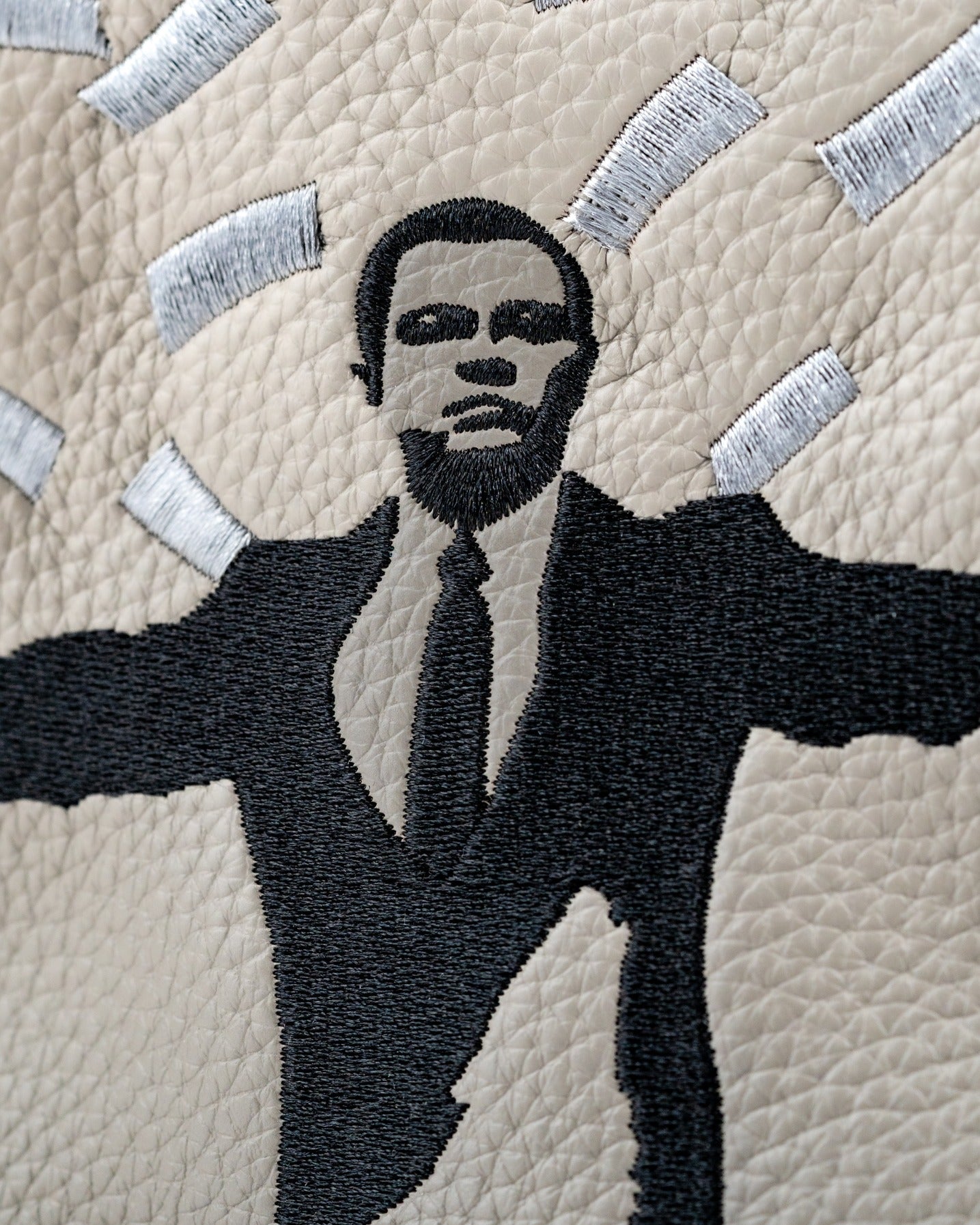 Stratton Oakmont driver cover featuring a bold embroidered design of a suited figure with outstretched arms on textured leather.