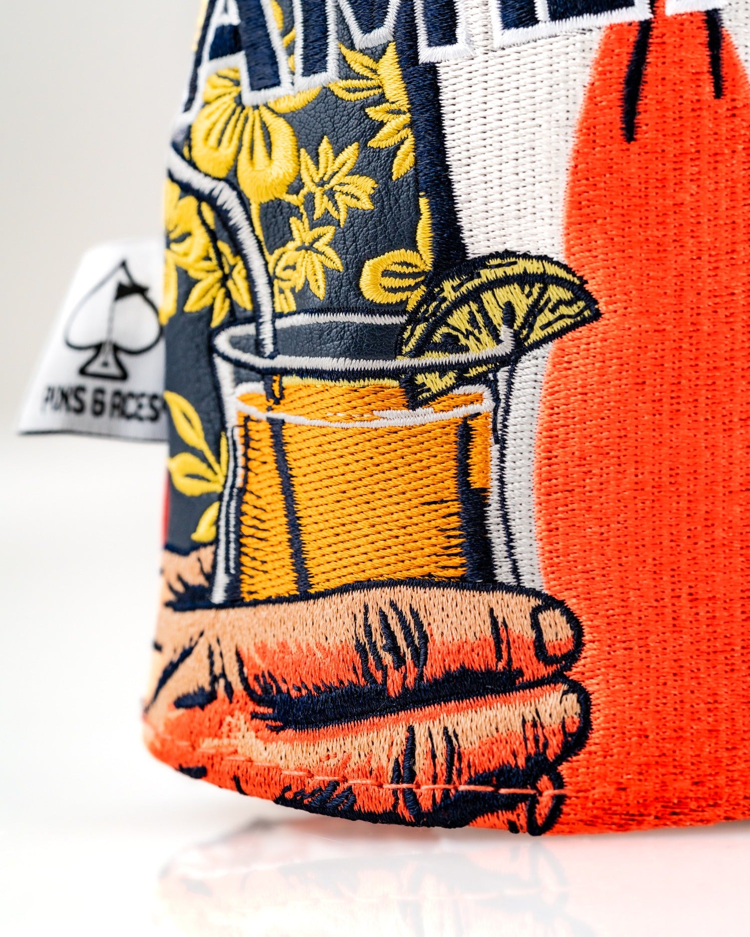 Bold driver cover featuring vibrant embroidery of a hand holding a tropical drink, perfect for stylish golfers.