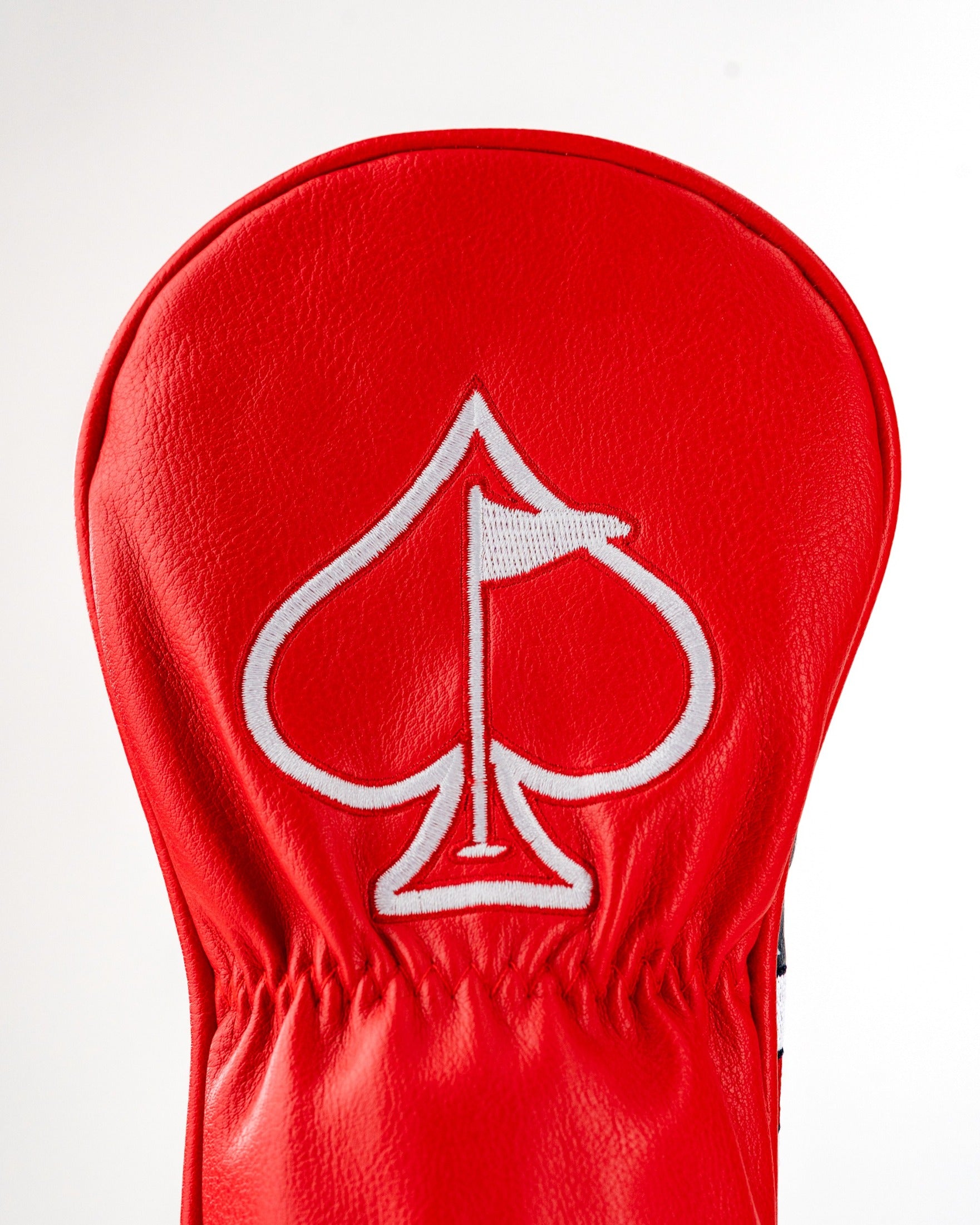 Bold red fairway cover featuring a white spade logo, designed for golfers seeking standout accessories on the course.