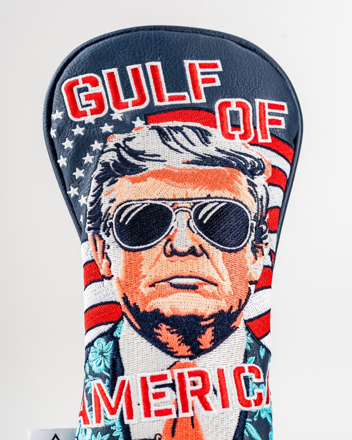 Bold golf hybrid cover featuring a stylized portrait of a man in sunglasses with "Gulf of America" text and American flag background.