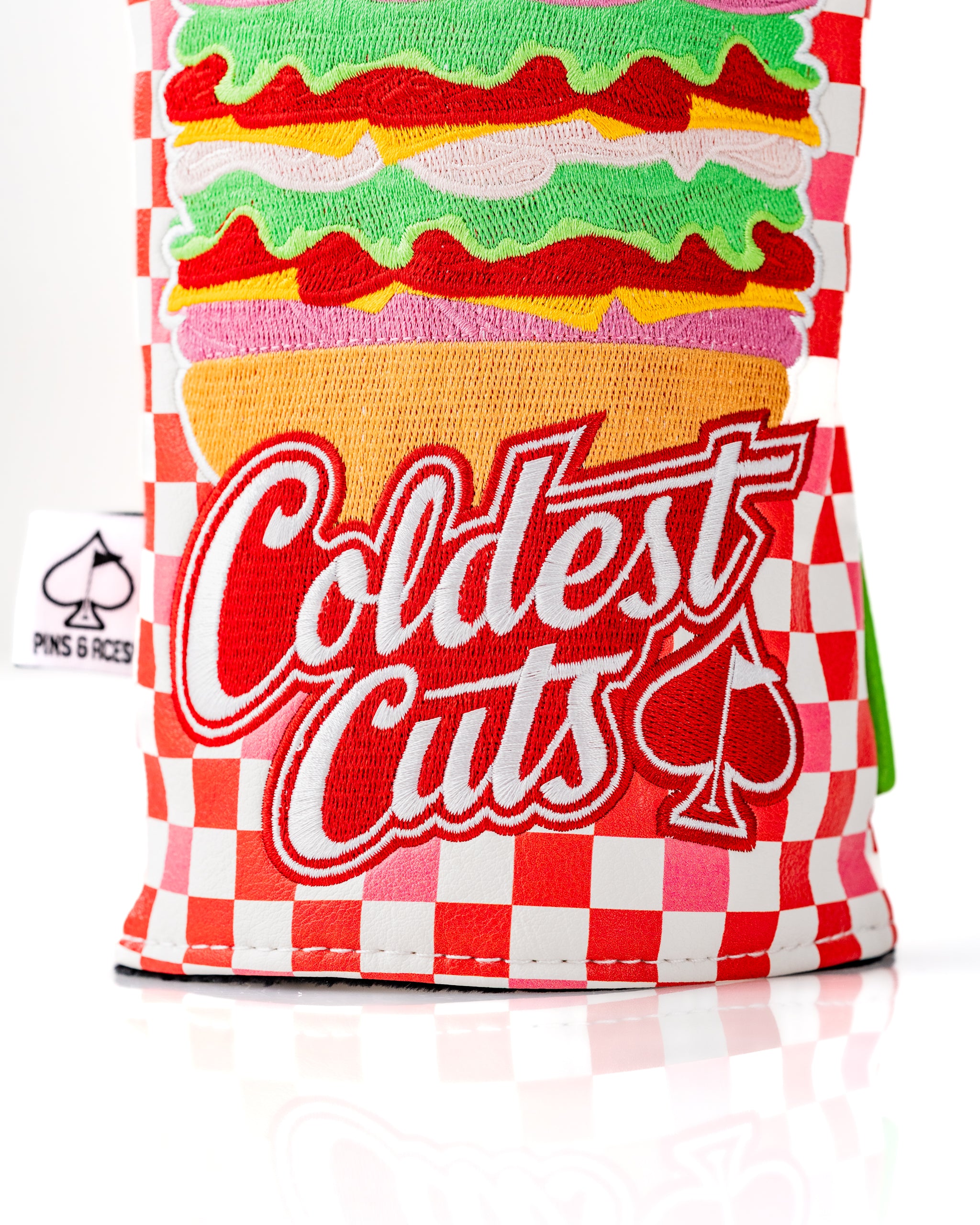 Bold driver cover featuring a colorful sandwich design with the text "Coldest Cuts" and a checkered pattern.