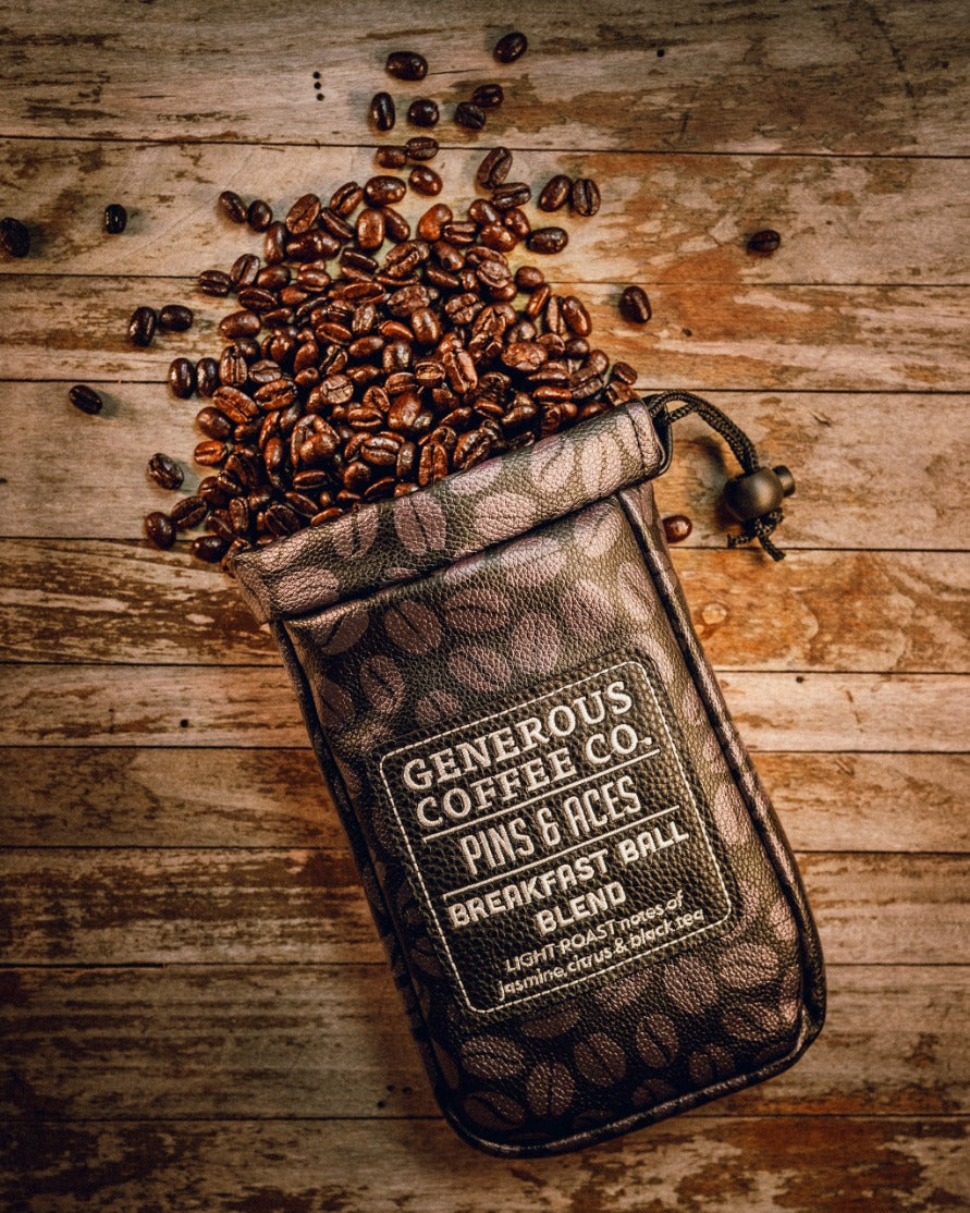Generous Coffee valuables pouch with coffee beans spilling out, featuring a stylish design and logo.