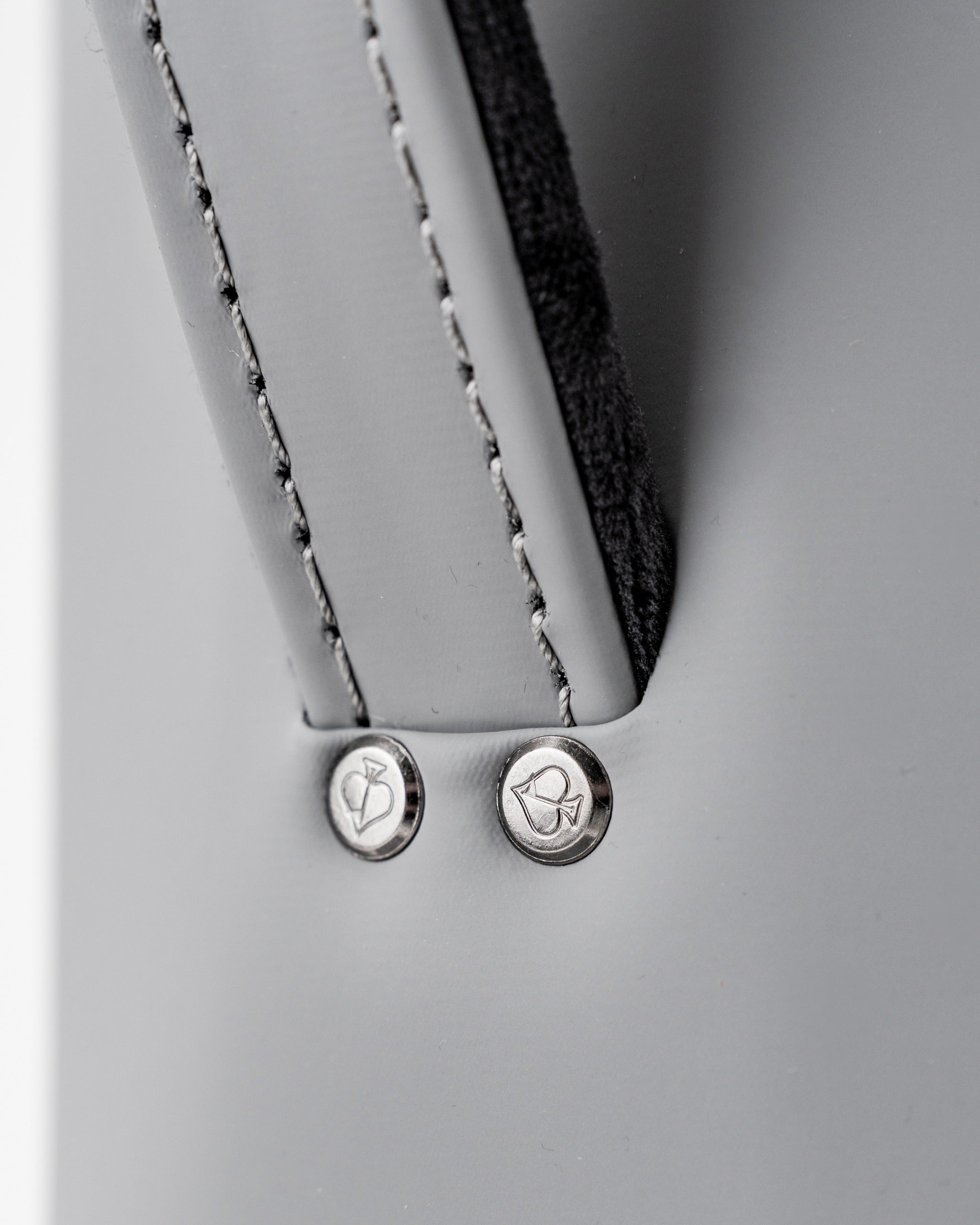 Close-up of the Den Caddy in Flat Ash, showcasing sleek gray material and stylish metal accents for golf enthusiasts.