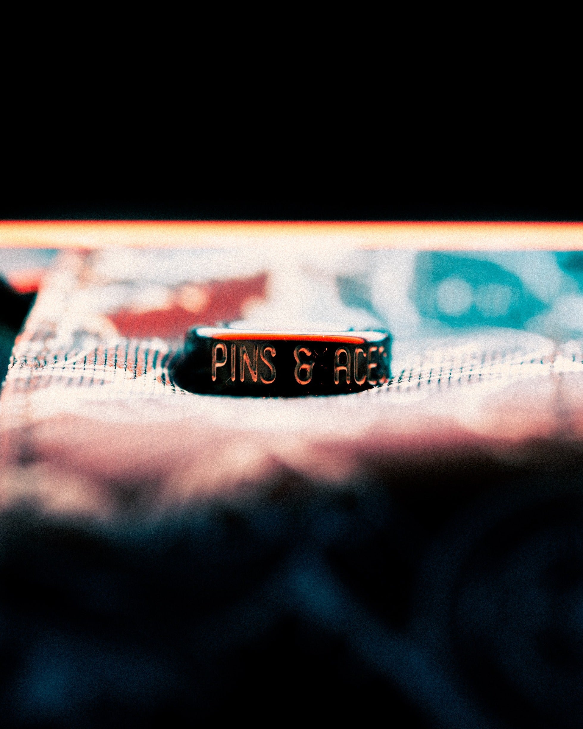 Close-up of a Pins & Aces branded item from the Black Friday 2025 Mystery Box, showcasing bold golf apparel style.