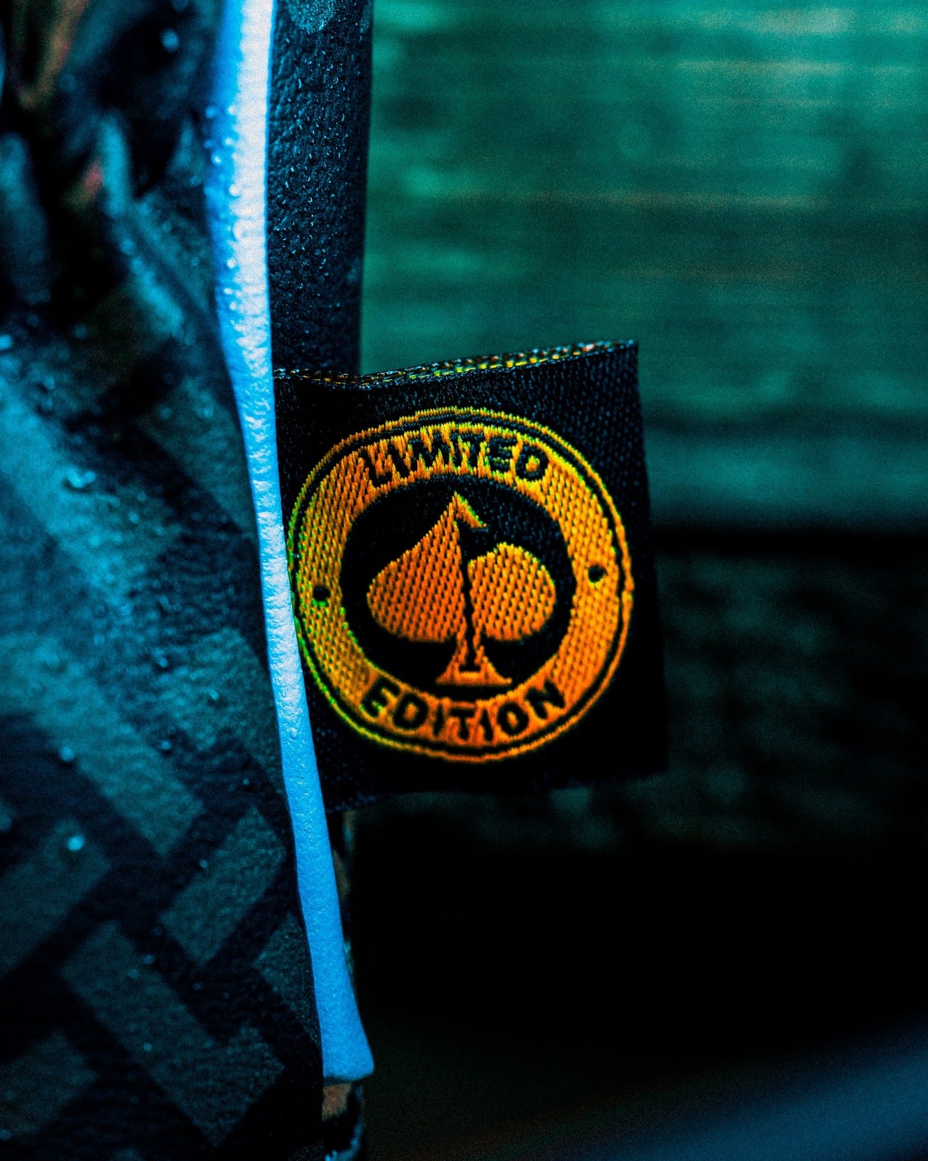 Close-up of a limited edition tag on a mystery box, featuring a spade logo and vibrant orange detailing.