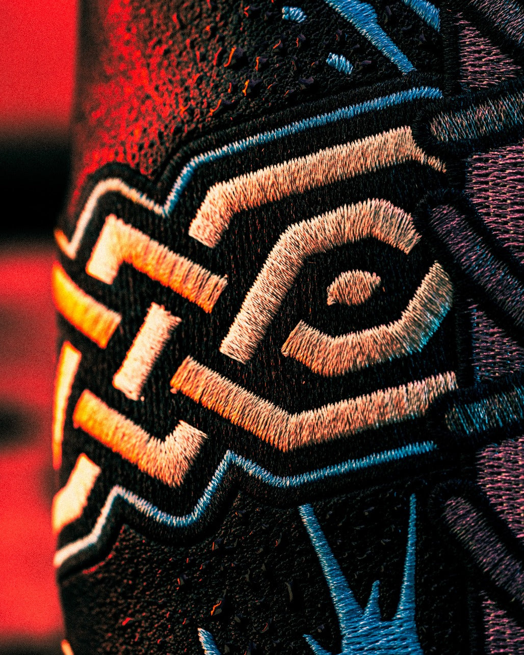 Close-up of intricate embroidery on a mystery box, showcasing bold patterns and vibrant colors for Black Friday 2025.