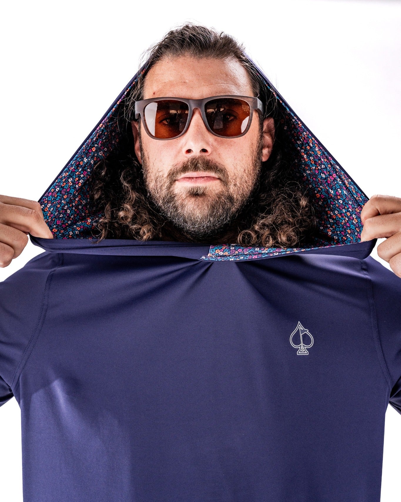 Man wearing a lavender performance golf hoodie with a floral-patterned lining, showcasing a stylish design.