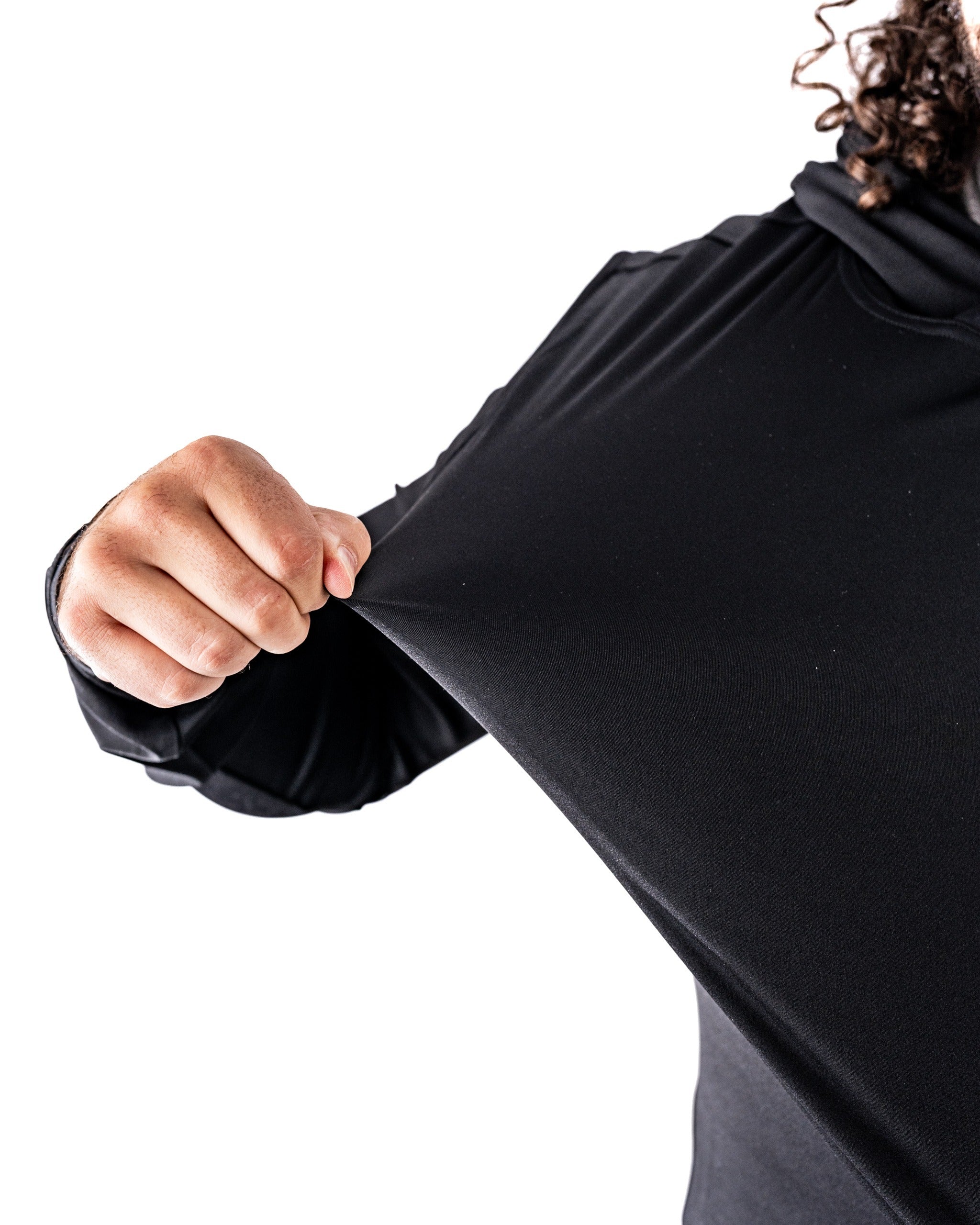 Performance Golf Hoodie in black, showcasing a hand pulling the fabric to highlight its stretch and comfort.