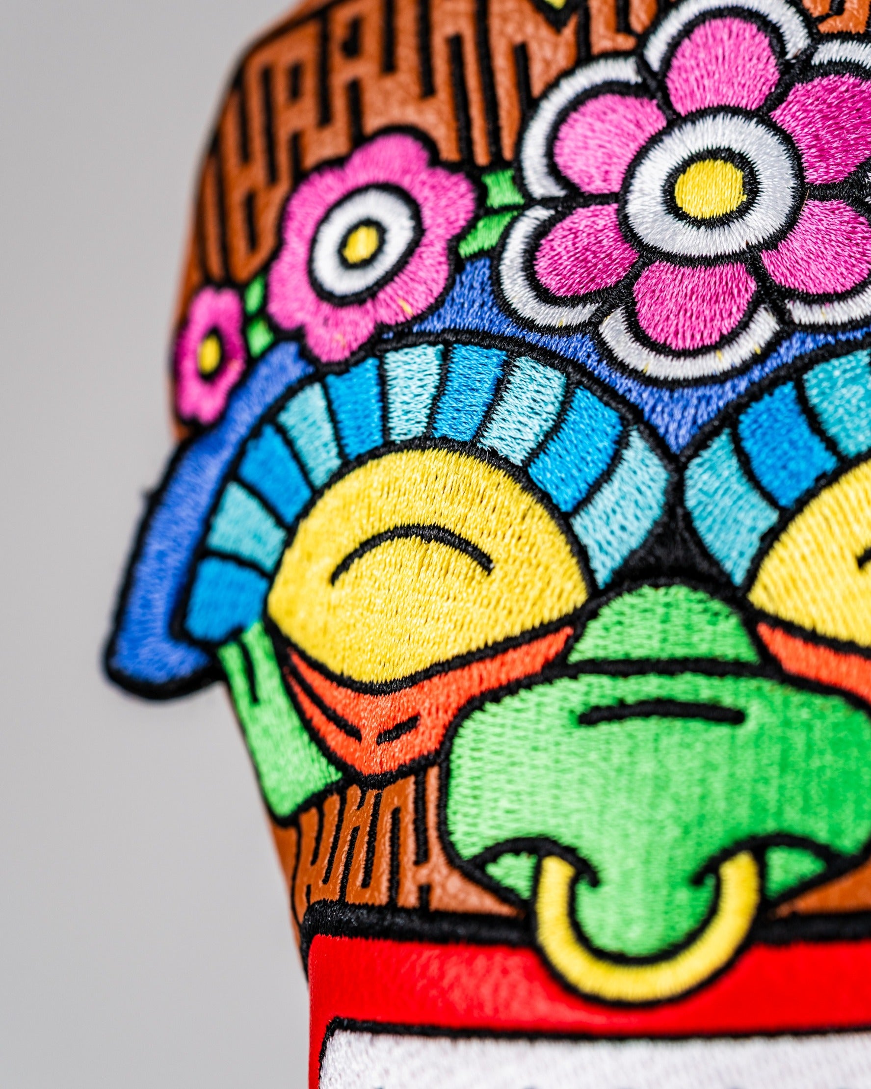 Colorful Tiki hybrid golf cover featuring intricate embroidery of flowers and a tiki face design, perfect for unique style on the course.