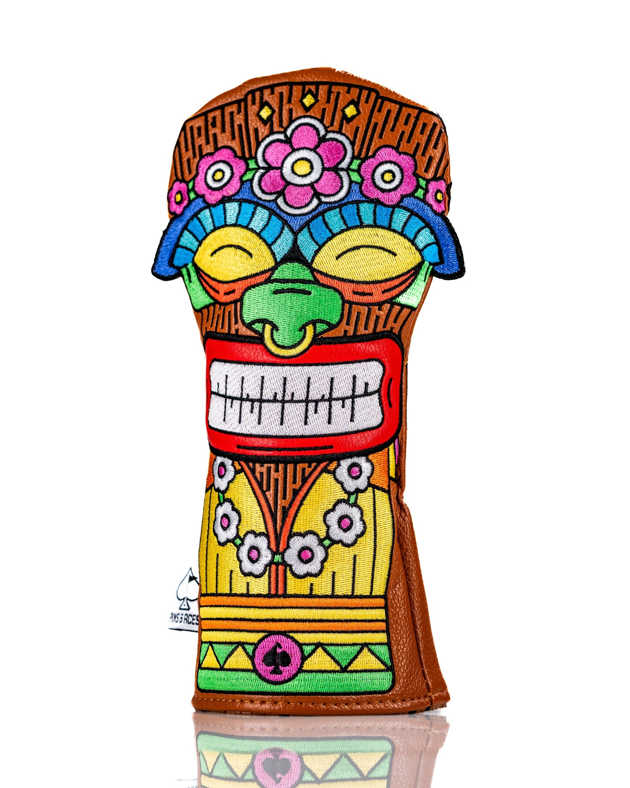 Colorful Tiki hybrid golf club cover featuring a vibrant tiki mask design with floral accents and a leather base.