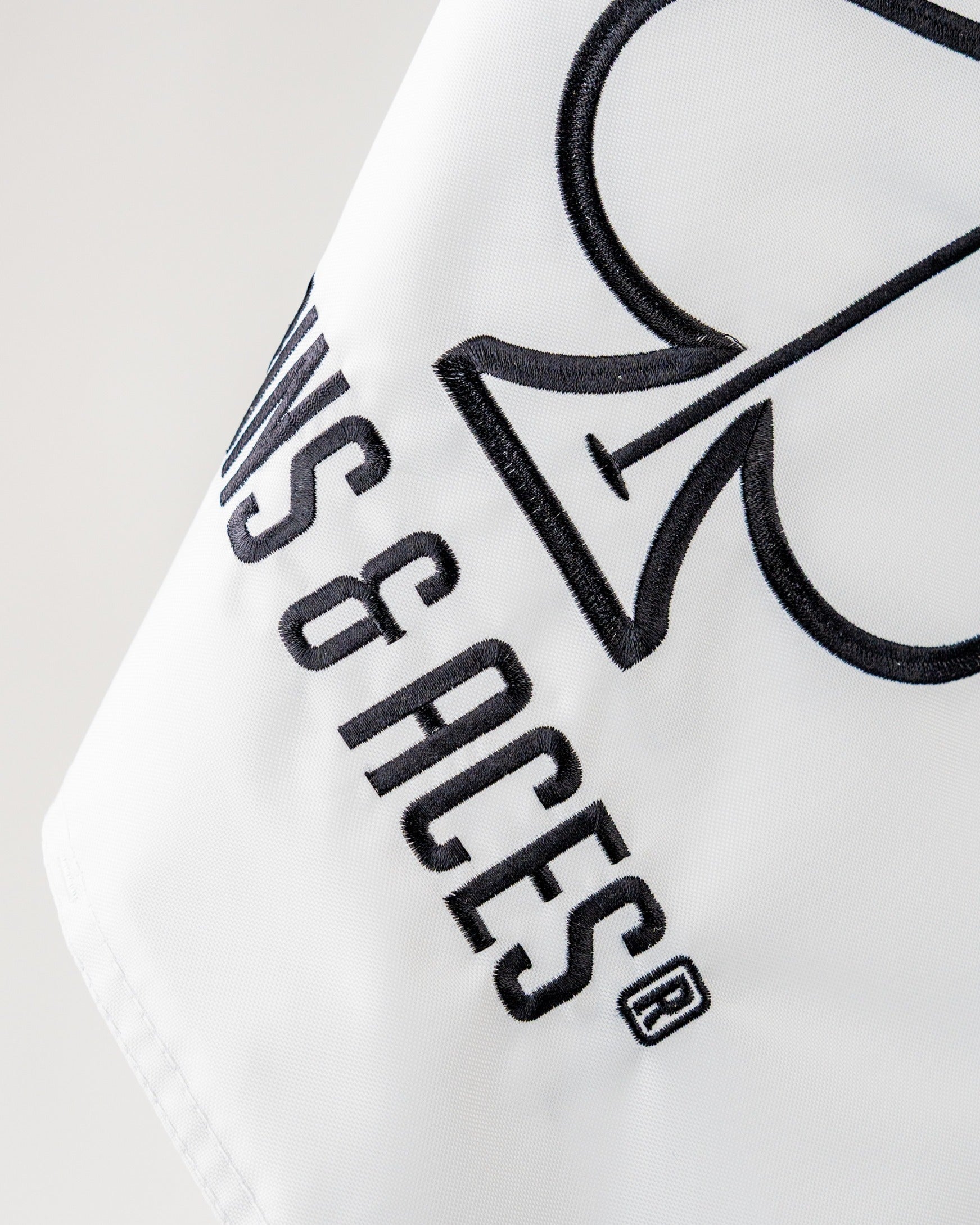 Bold white golf flag featuring the Pins and Aces logo with a spade design, perfect for adding flair to the course.