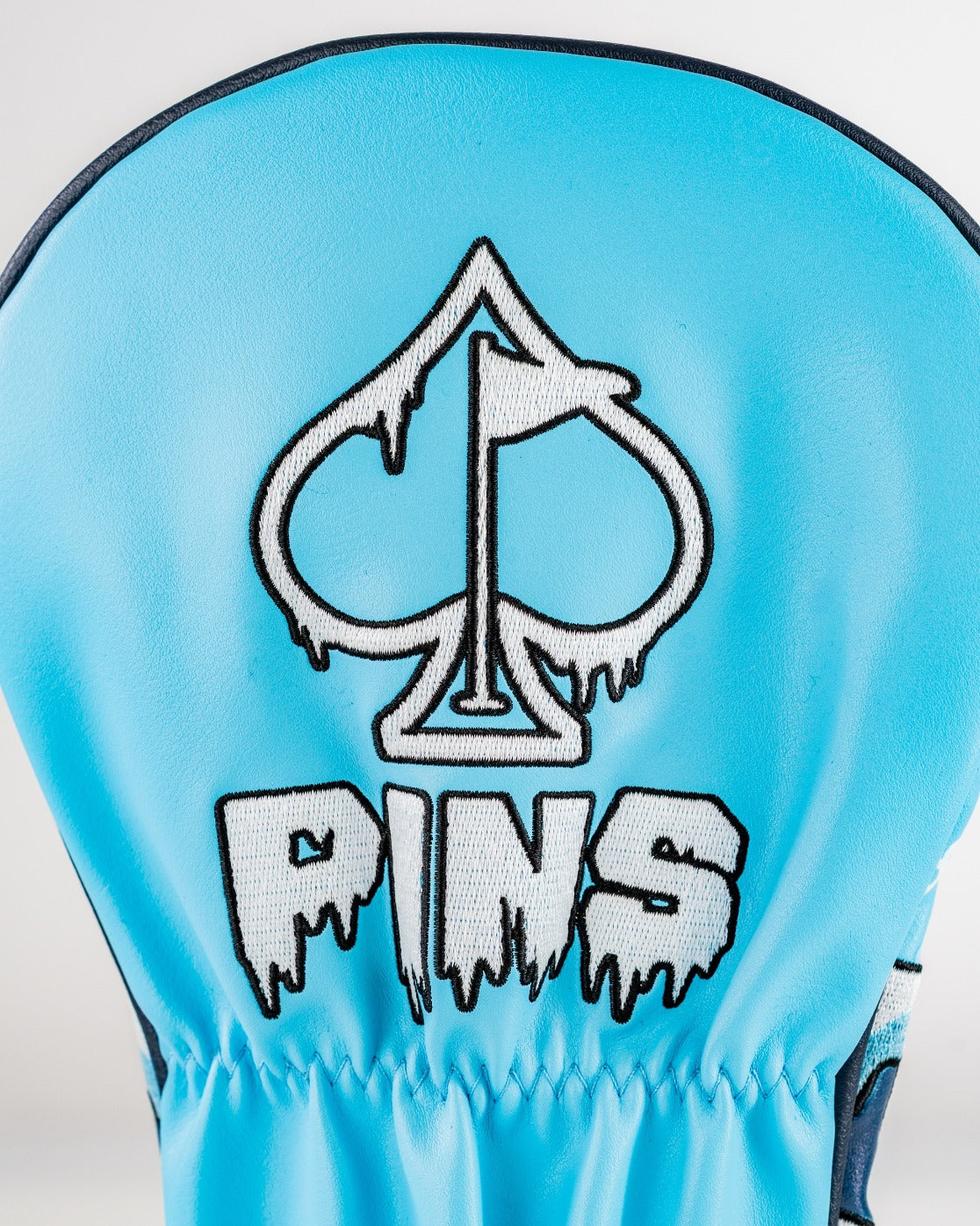 Blue driver cover featuring a snowman design and the Pins logo with a dripping effect, perfect for standout golf style.
