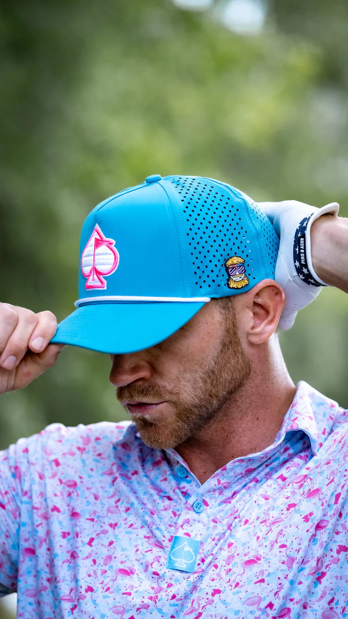 Baby blue perforated rope hat featuring a spade logo, worn by a golfer adjusting it on the course.
