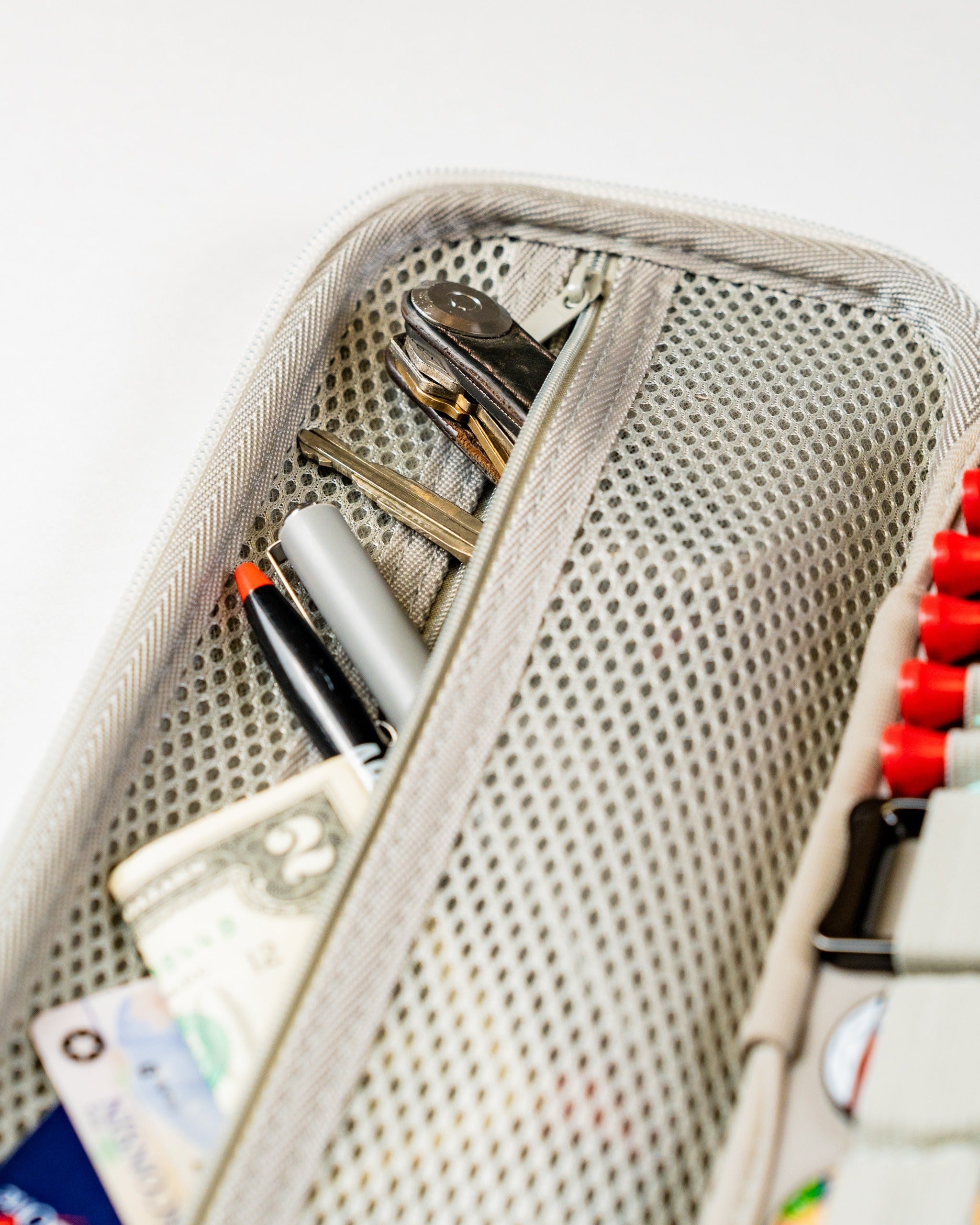 Gray glove and accessory caddie featuring a mesh pocket for organizing golf essentials like tools, cash, and pens.