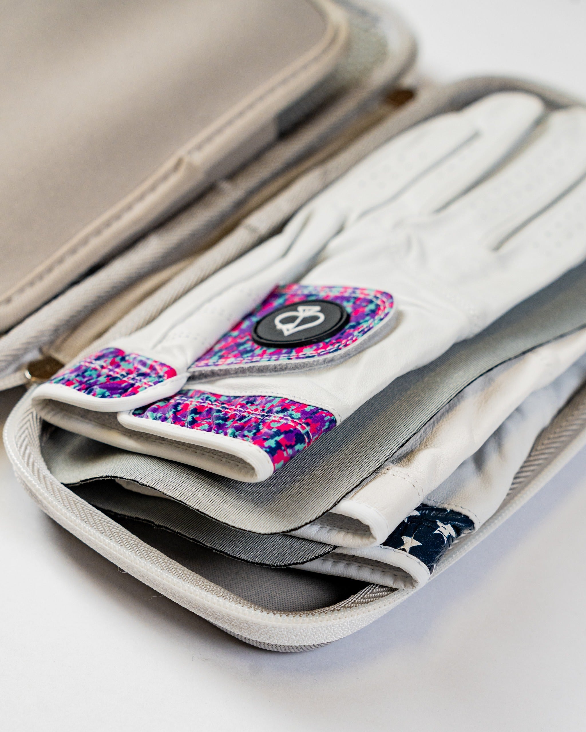 Gray glove and accessory caddie featuring compartments for golf gloves and accessories, showcasing a stylish design.