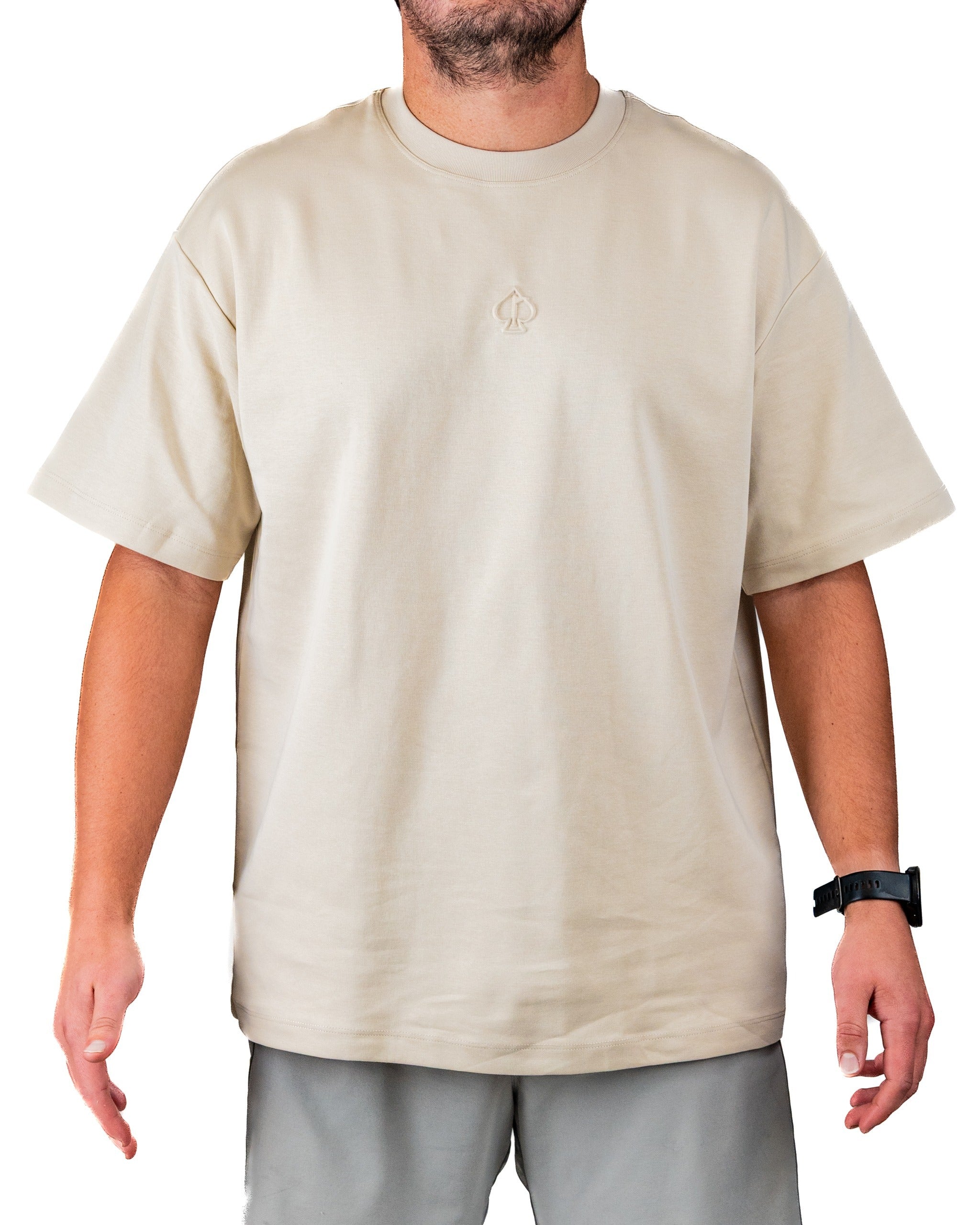 Cream embossed spade tee shirt on a man, featuring a relaxed fit and minimalist design, perfect for stylish golfers.