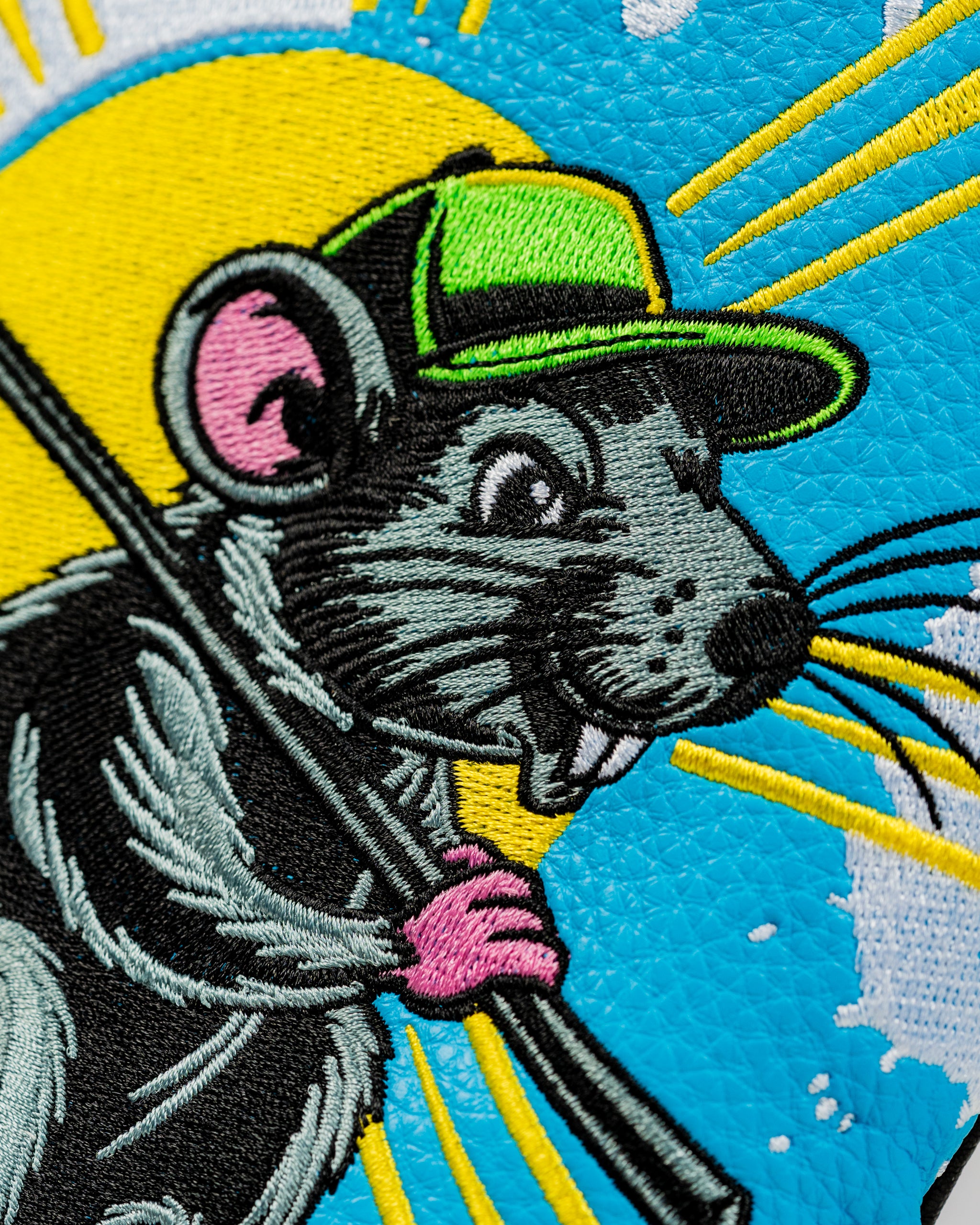Colorful driver cover featuring a playful cartoon rat wearing a cap, holding a golf club against a bright background.