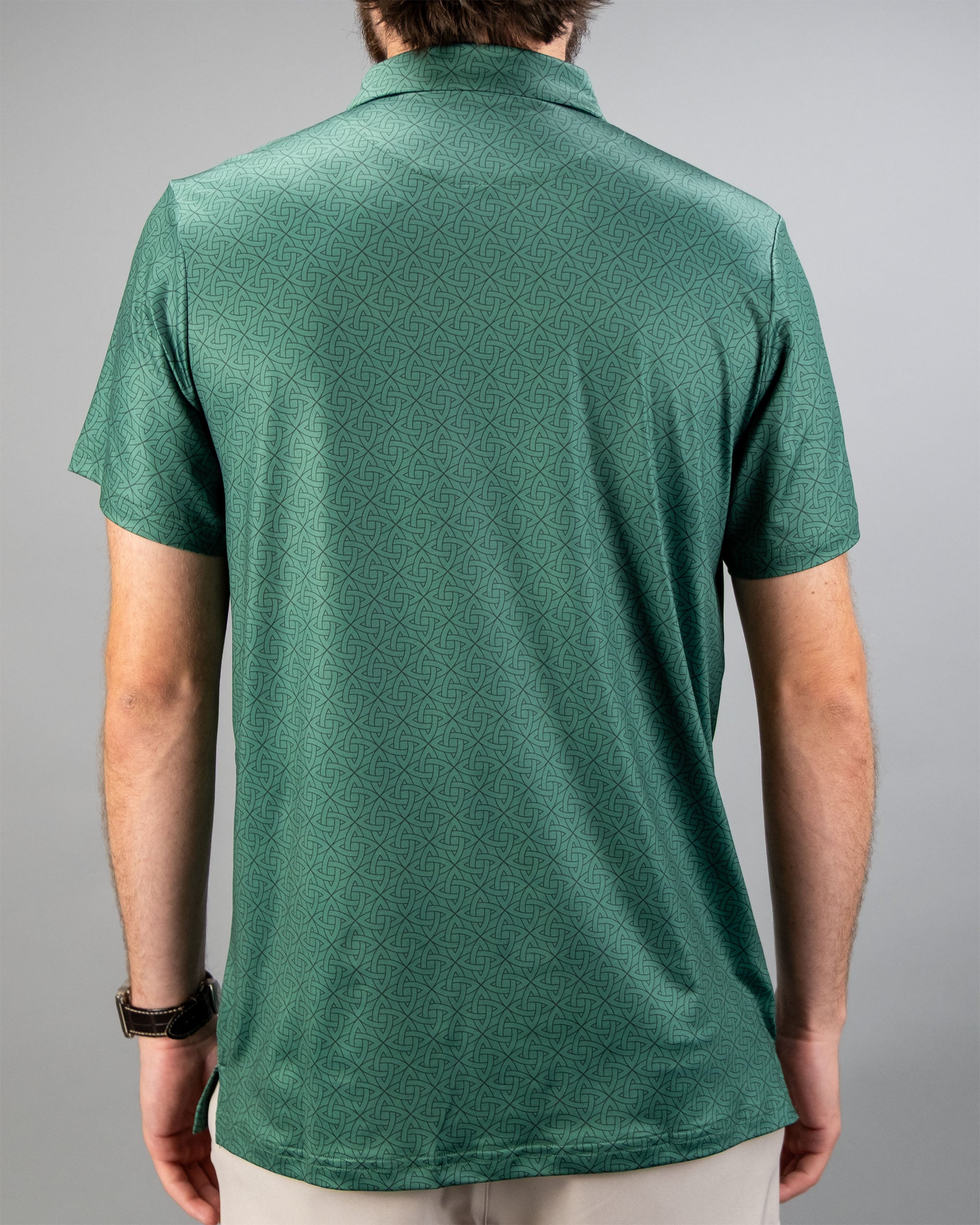 Back view of a man wearing an emerald green polo shirt featuring a subtle geometric pattern.