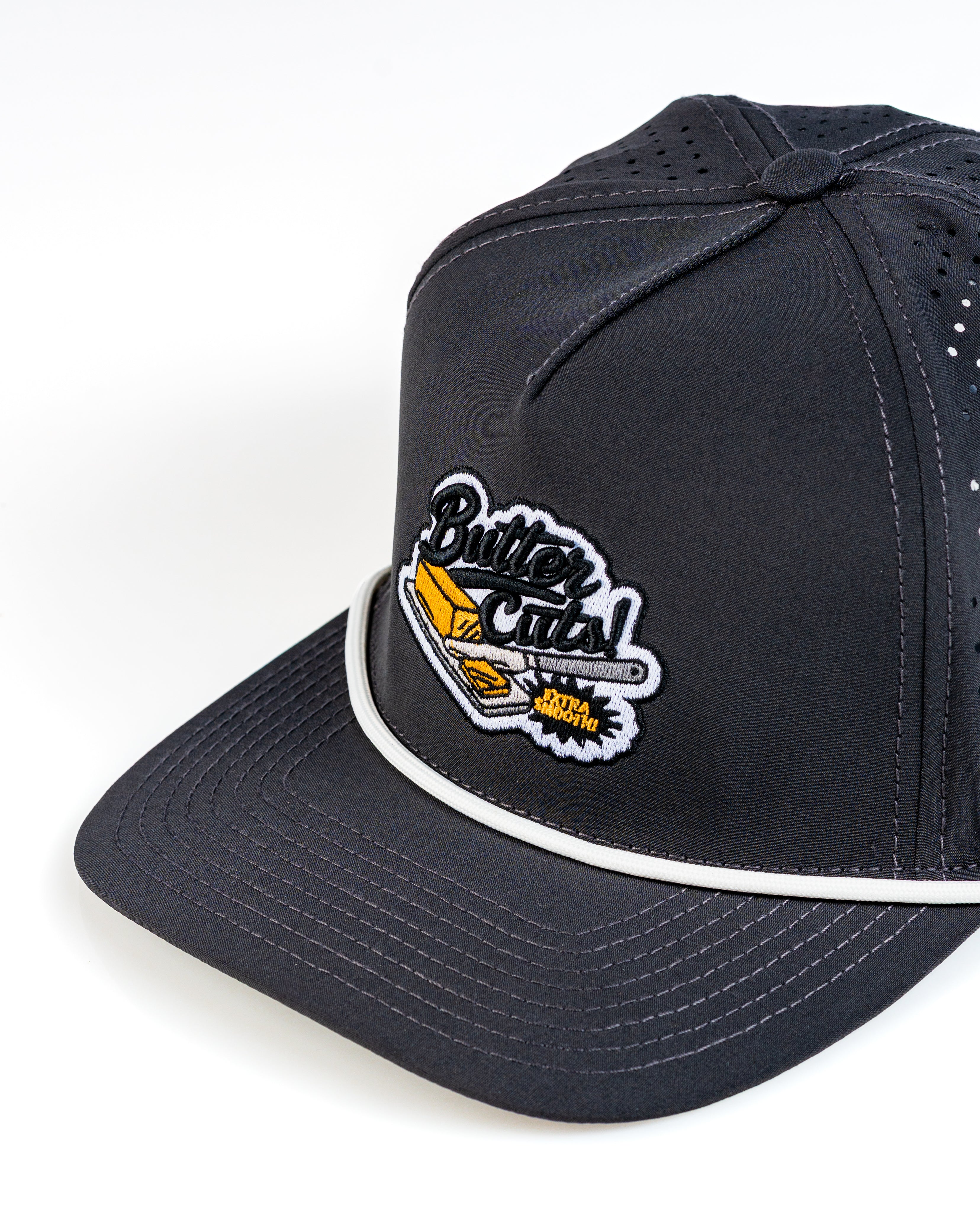 Perforated Rope Hat in black featuring a colorful "Butter Cuts" logo and white detailing for a stylish golf accessory.