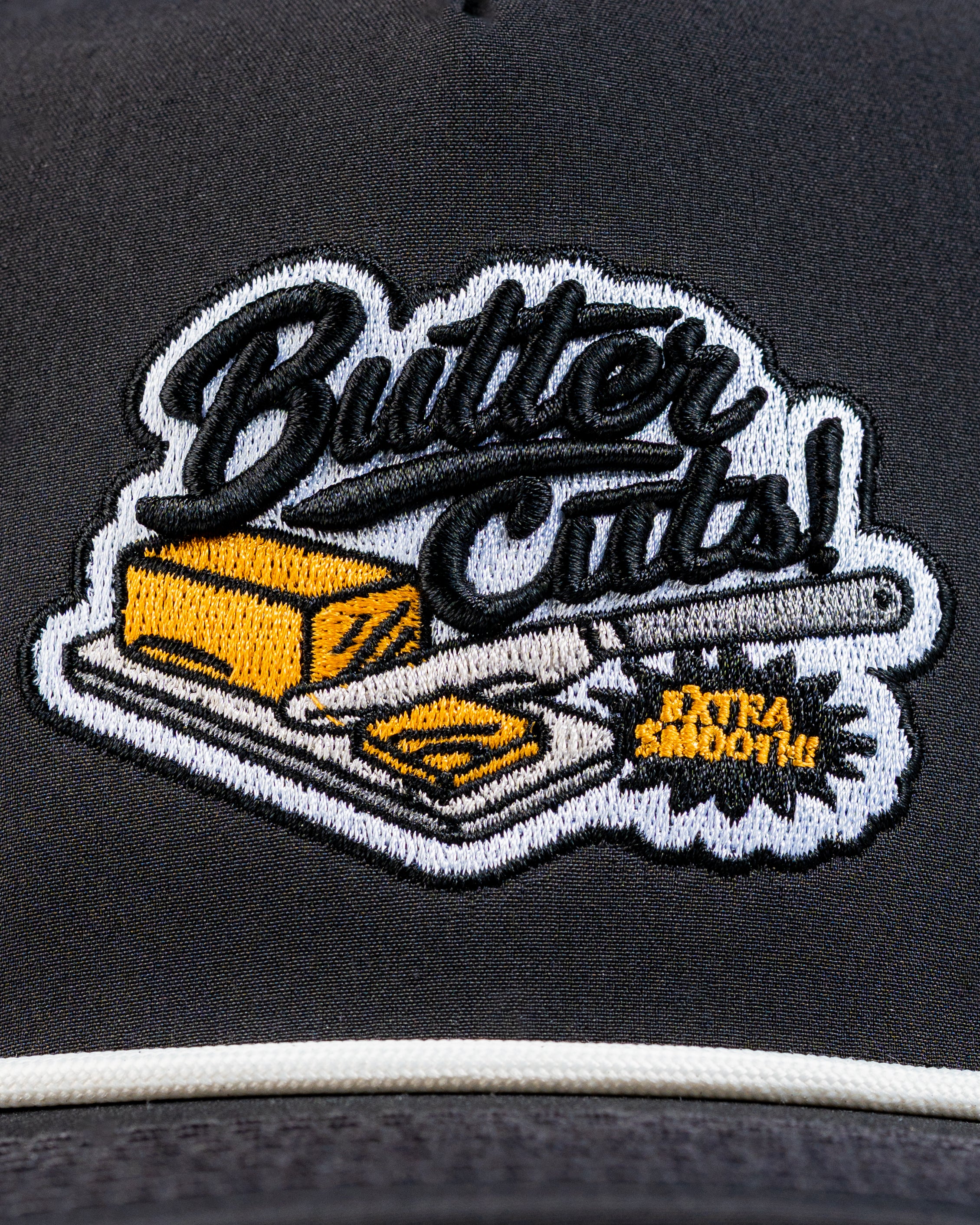 Perforated Rope Hat featuring a playful butter cuts design with a butter stick and knife, perfect for stylish golfers.