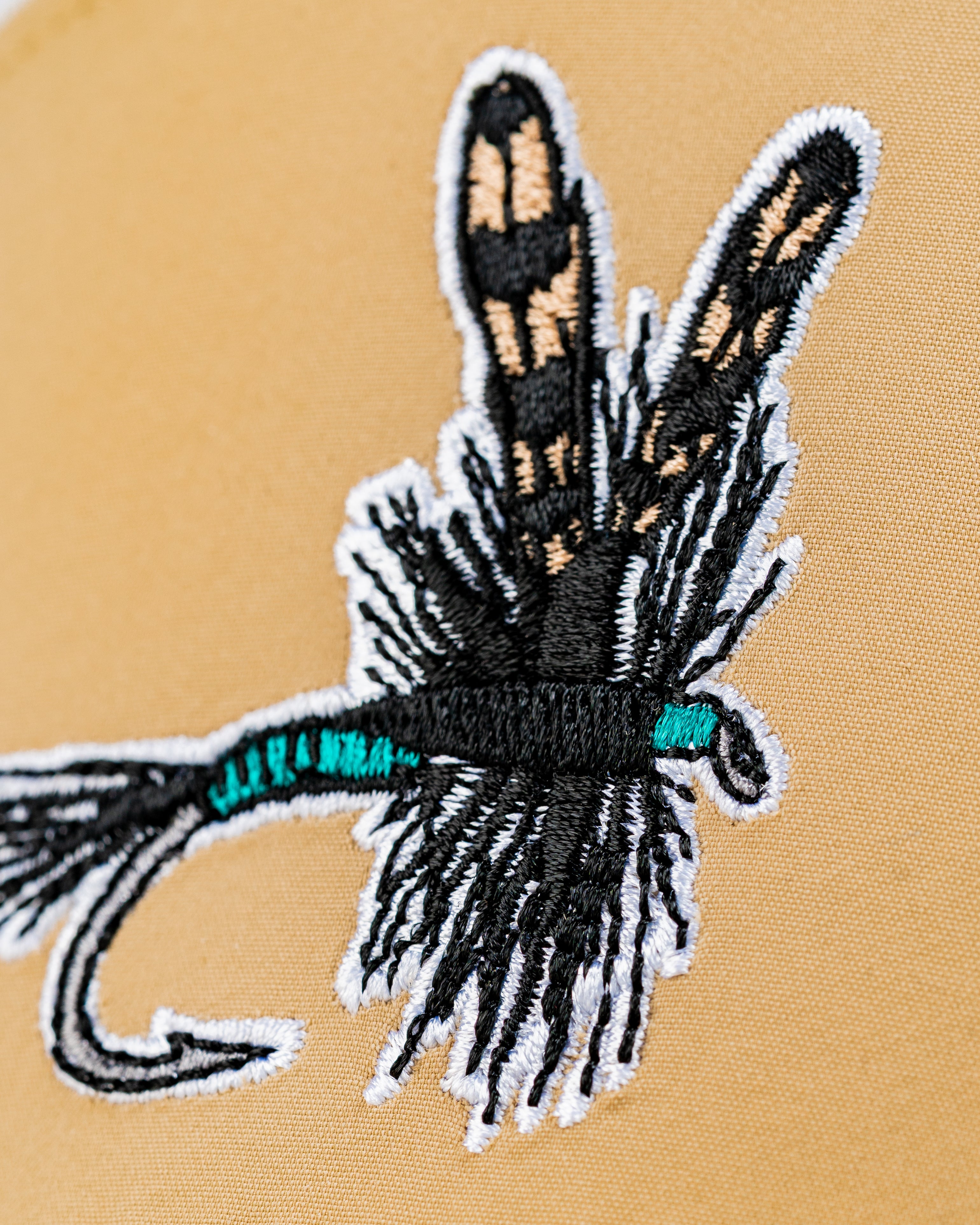 Close-up of the Tradesman Hat featuring an embroidered dry fly design, ideal for stylish golfers and outdoor enthusiasts.