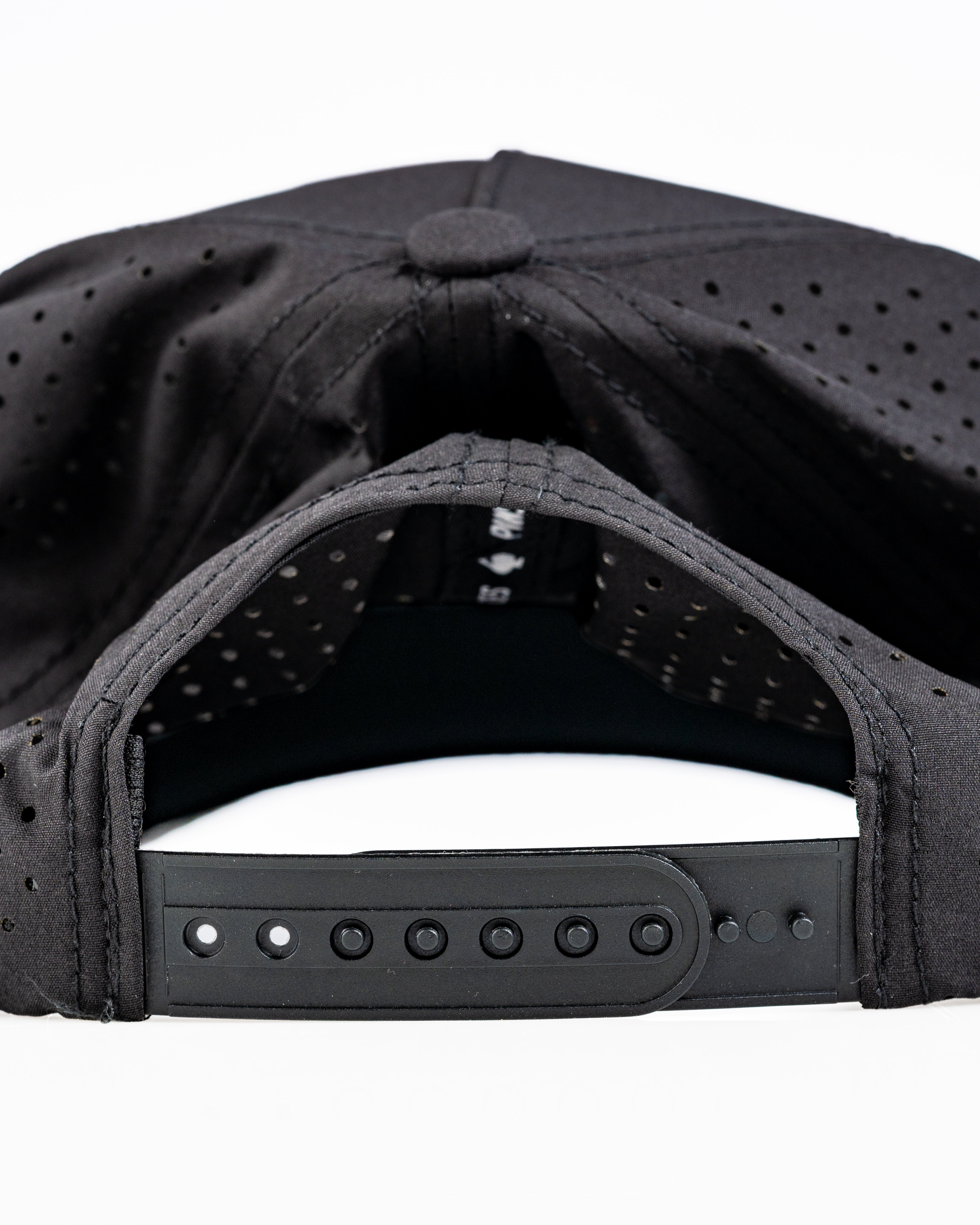 Perforated black rope hat featuring a snapback closure, designed for comfort and style on the golf course.