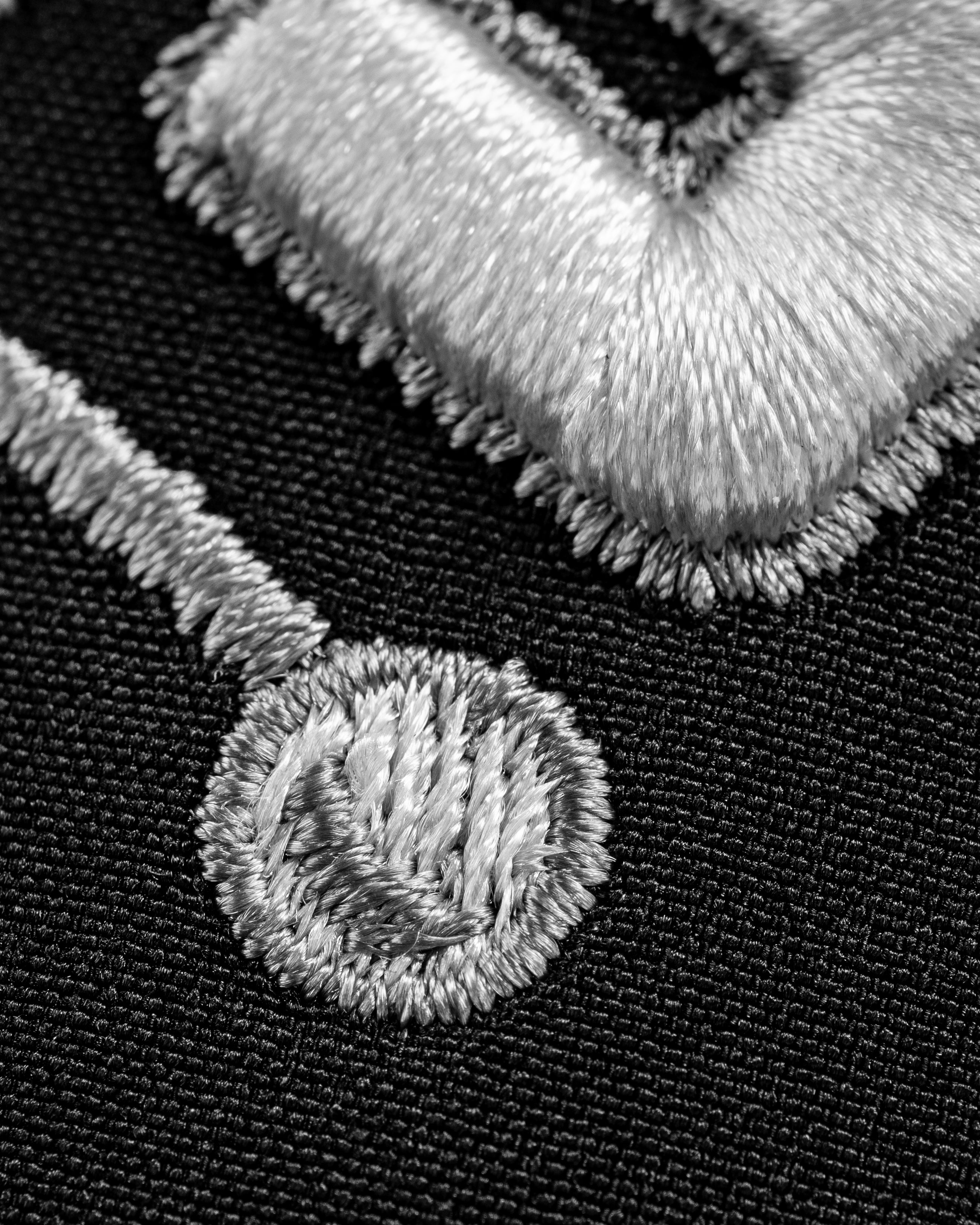 Close-up of the embroidered design on the Perforated Rope Hat - Slice, featuring a golf-themed motif in silver thread.