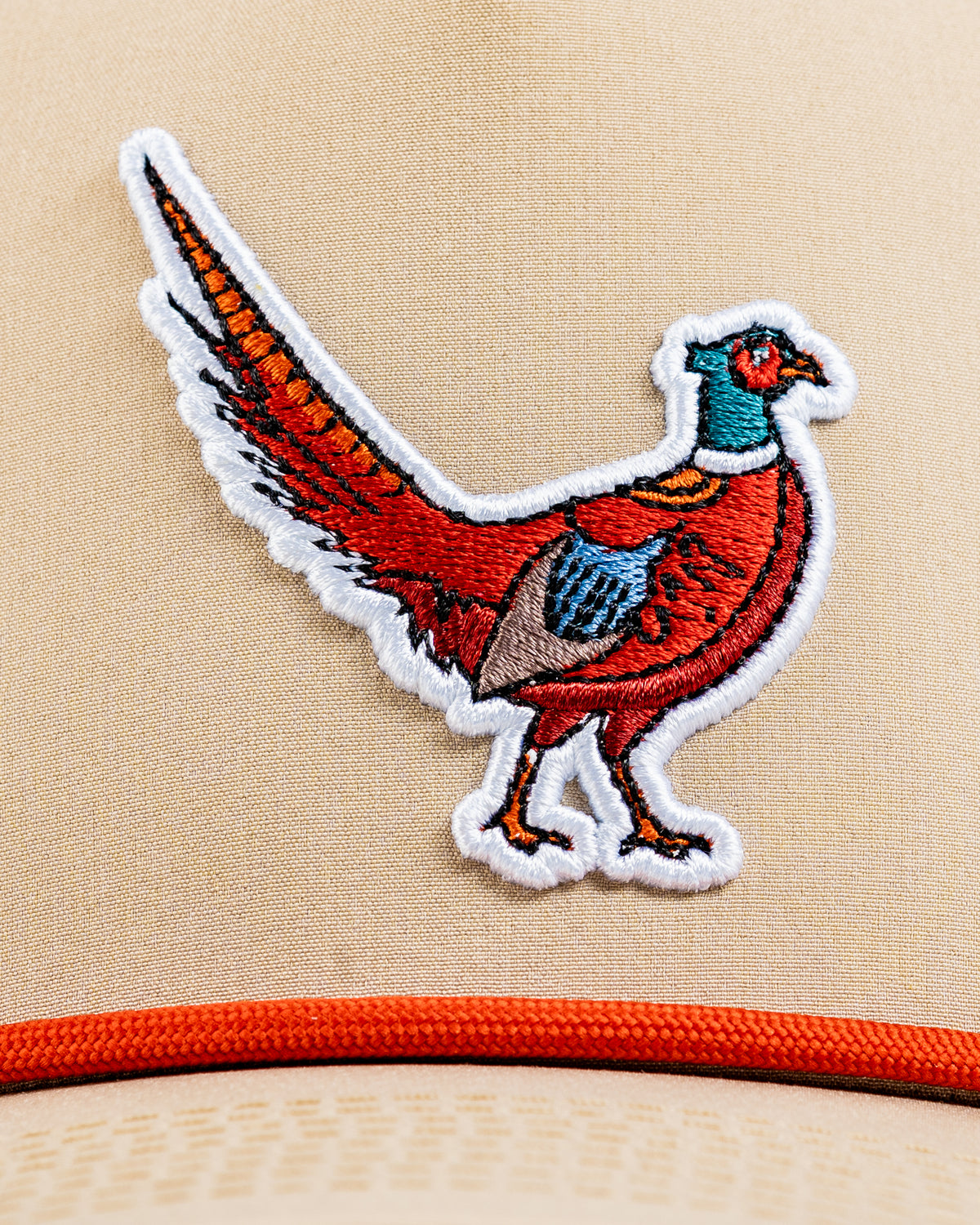 Beige perforated rope hat featuring a colorful embroidered pheasant design, perfect for stylish golfers.